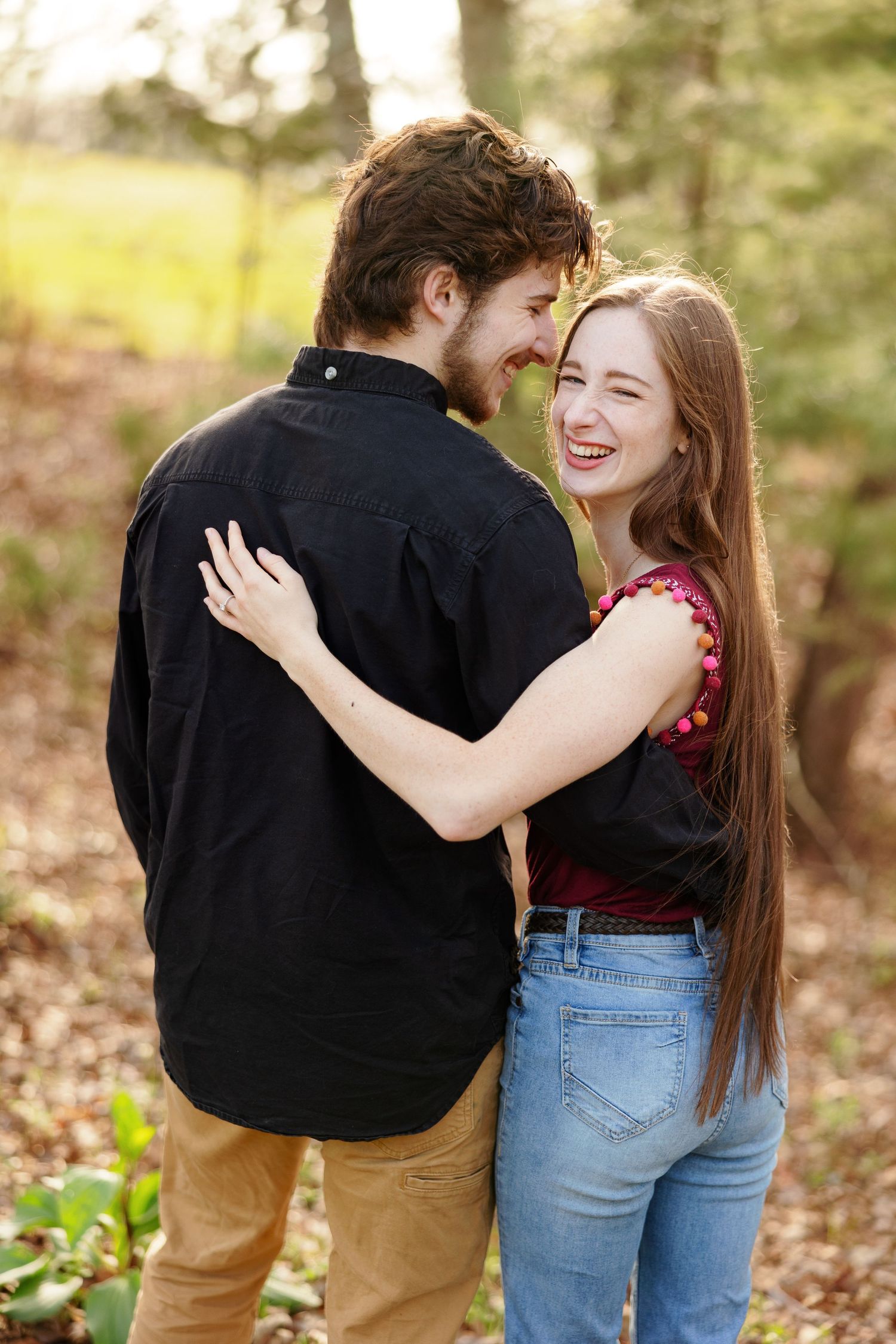 Young man makes his bride-to-be giggle in a hug for a portrait by Memphis wedding photographer Emily Joy Photography