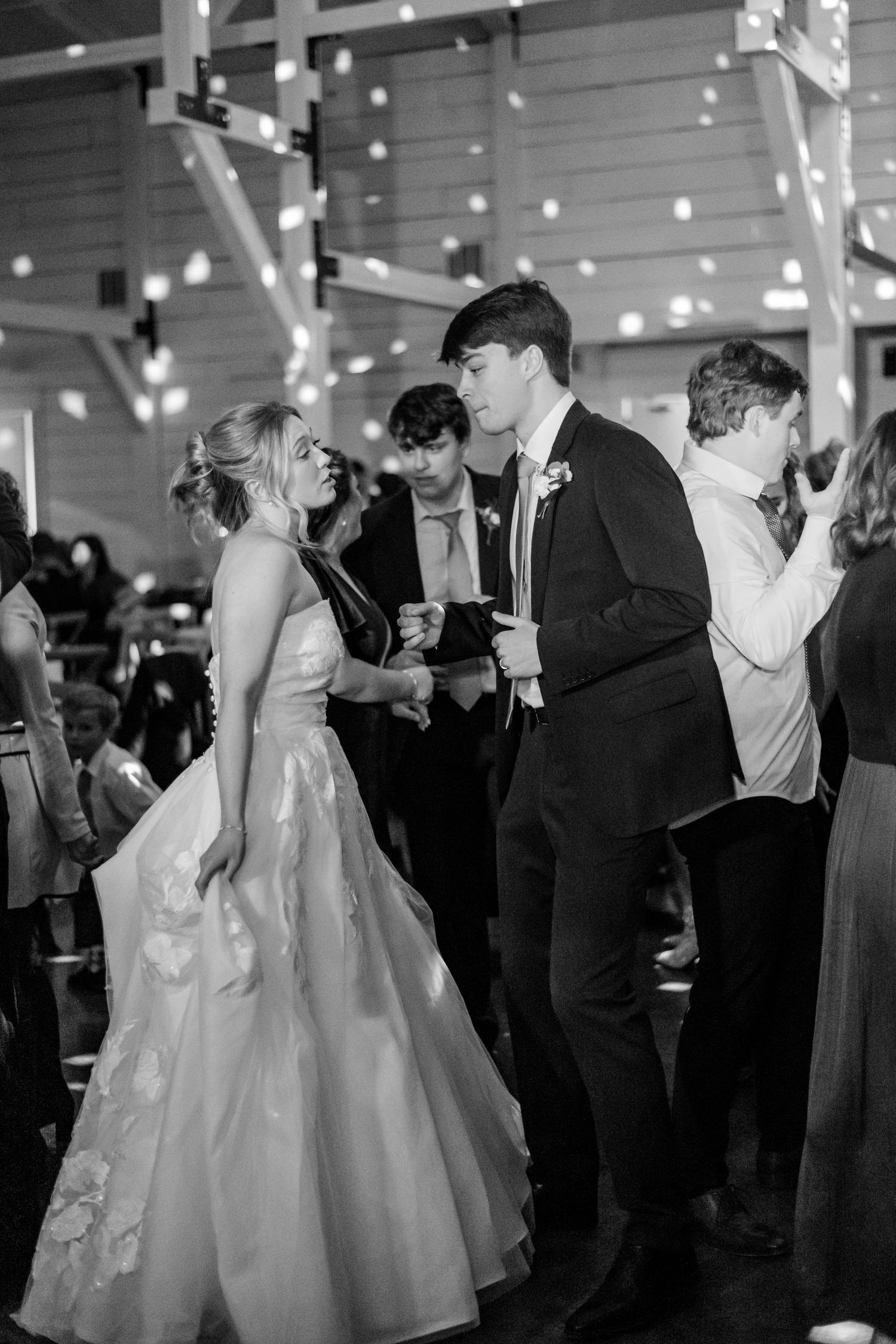 A black and white shot of the bride and groom dancing together at their wedding reception.