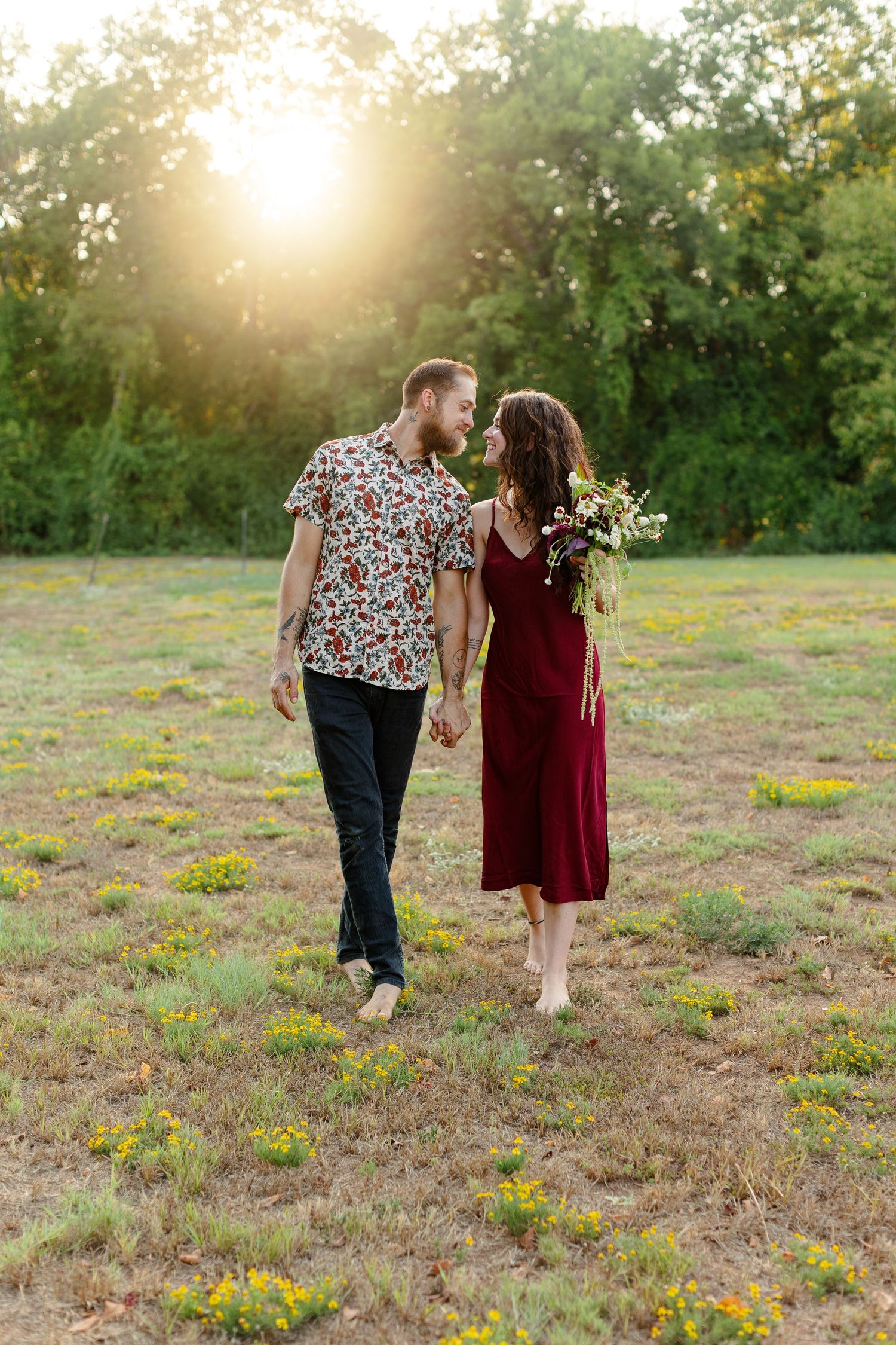 Engaged couple walking and smiling, backlit by sunset for a portrait  by Emily Joy Photography, now a wedding photographer in Memphis, TN.