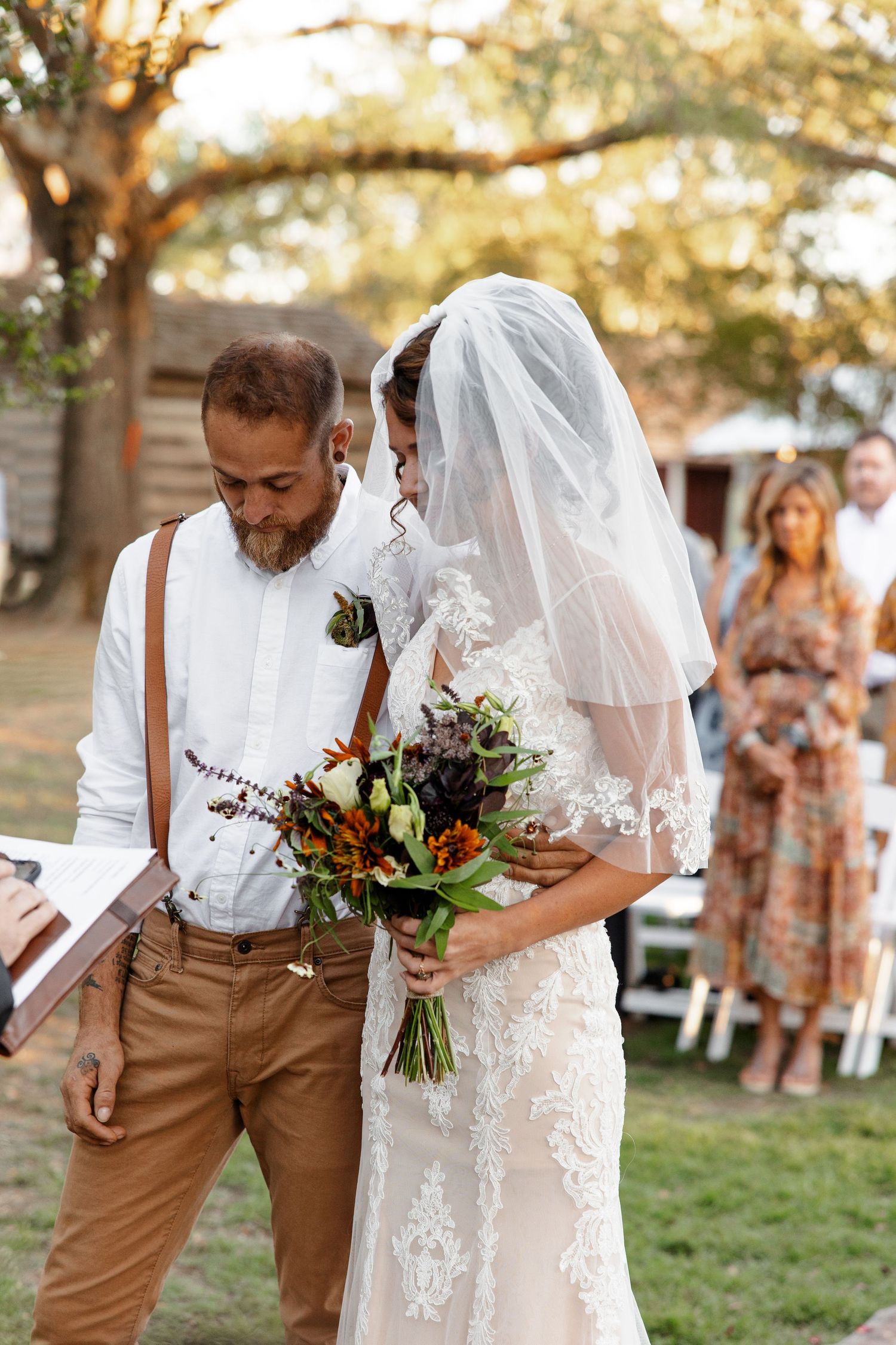 Bride and Groom praying during outdoor ceremony photographed by Emily Joy Photography, now a wedding photographer in Memphis, TN.