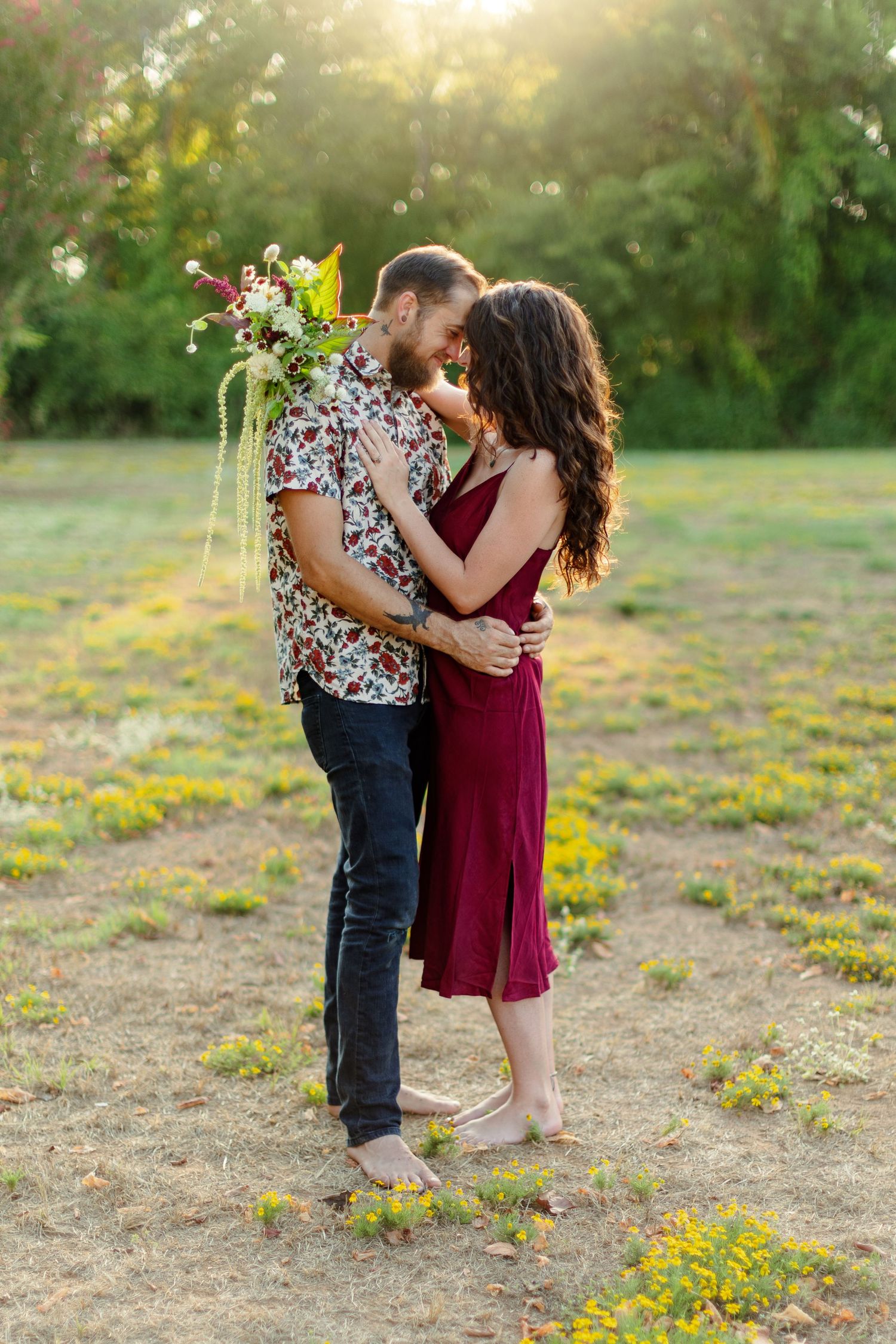 Engaged couple smiles at each other during sunset for a portrait  by Emily Joy Photography, now a wedding photographer in Memphis, TN.