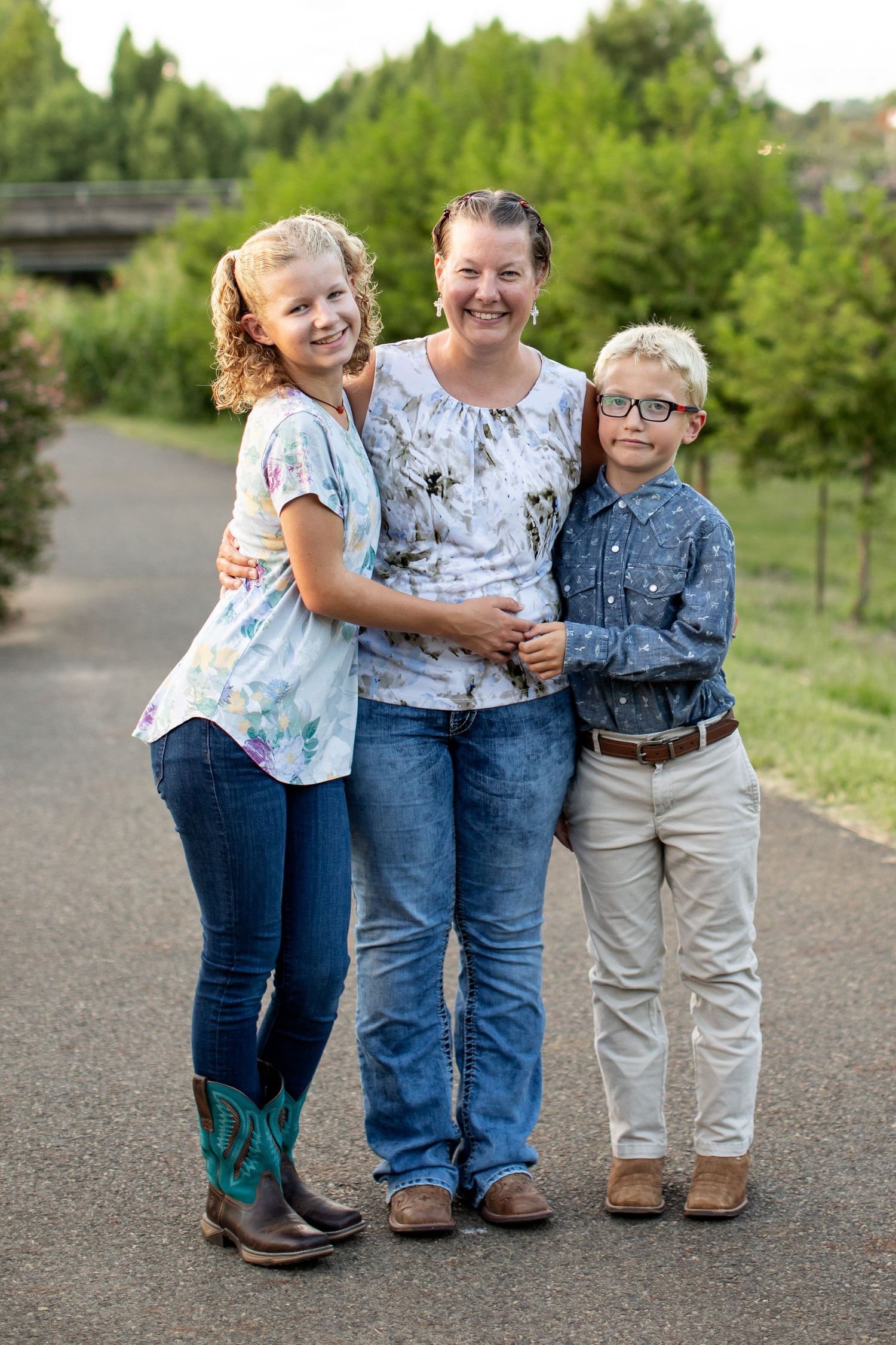 A mother hugging her two children smile for a portrait by Emily Joy Photography, now a wedding photographer in Memphis, TN.