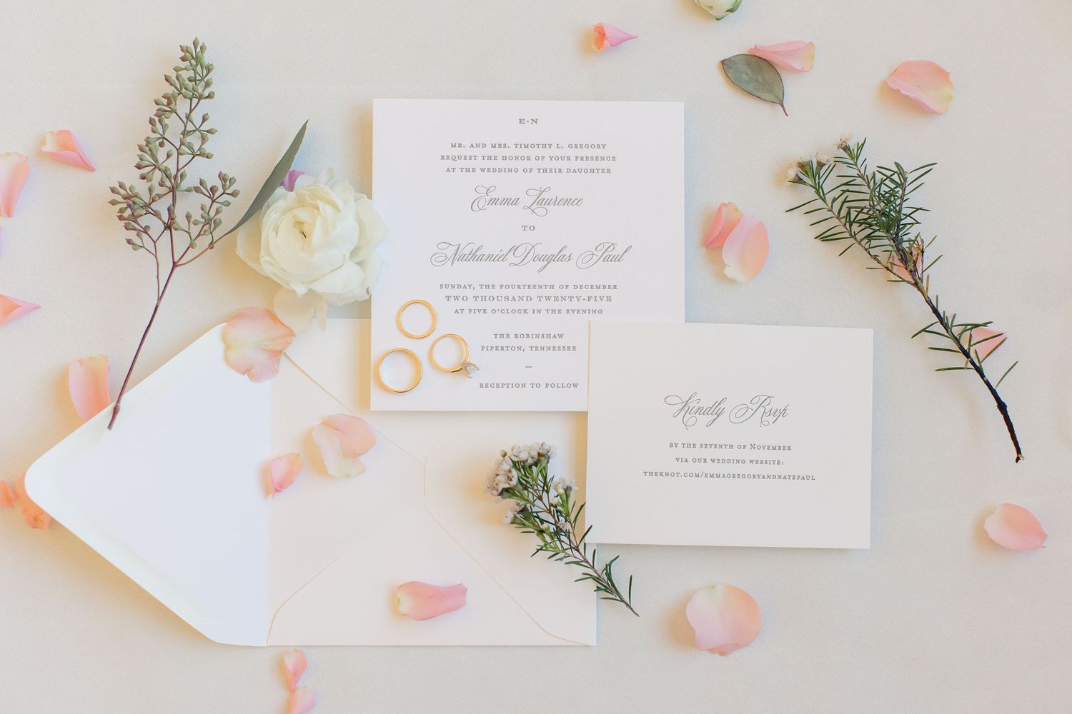 A simple and elegant portrait of a wedding invitation, surrounded by florals and rings. Image by Emily Joy, wedding photographer in Memphis.