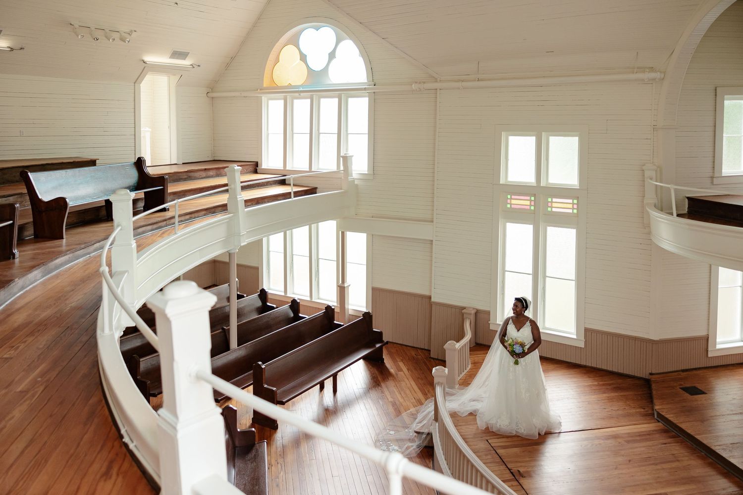A bride in an elegant gown stands in a Victorian chapel for portrait by Memphis Wedding Photographer Emily Joy Photography