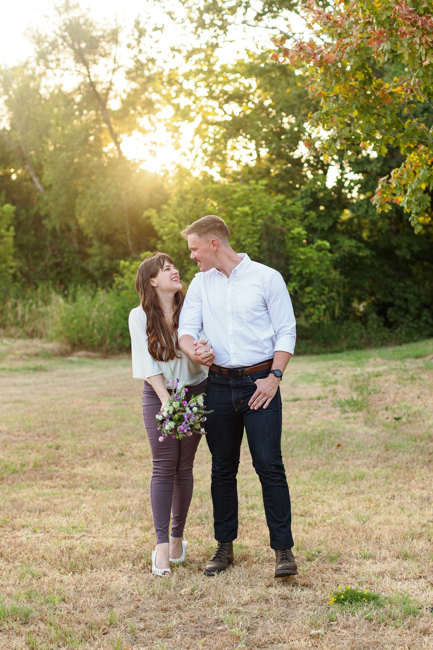 An engaged couple walking and holding hands for a portrait by Emily Joy Photography, now a wedding photographer in Memphis, TN.