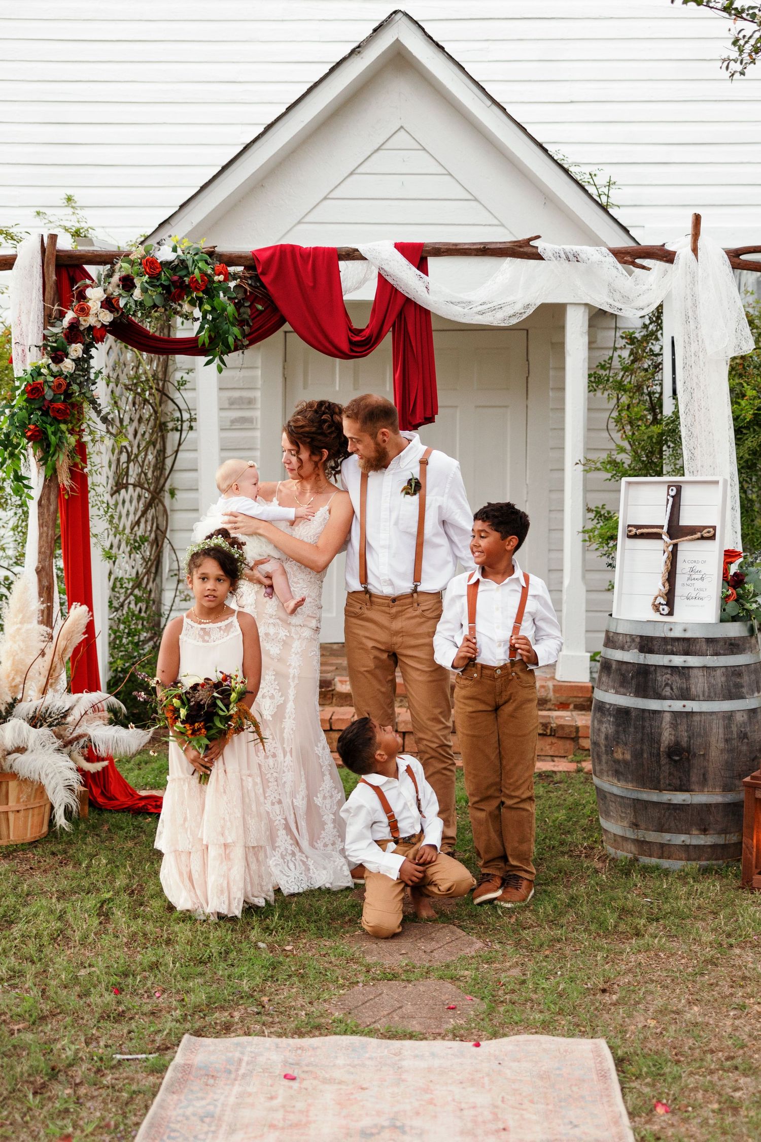Bride and Groom interact with ringbearers and flower girls for a portrait by Emily Joy Photography, now a wedding photographer in Memphis.