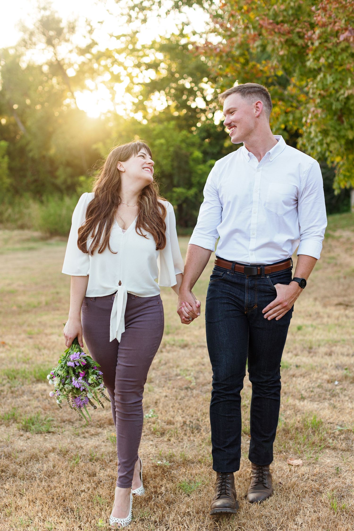 An engaged couple walking and holding hands for a portrait by Emily Joy Photography, now a wedding photographer in Memphis, TN.