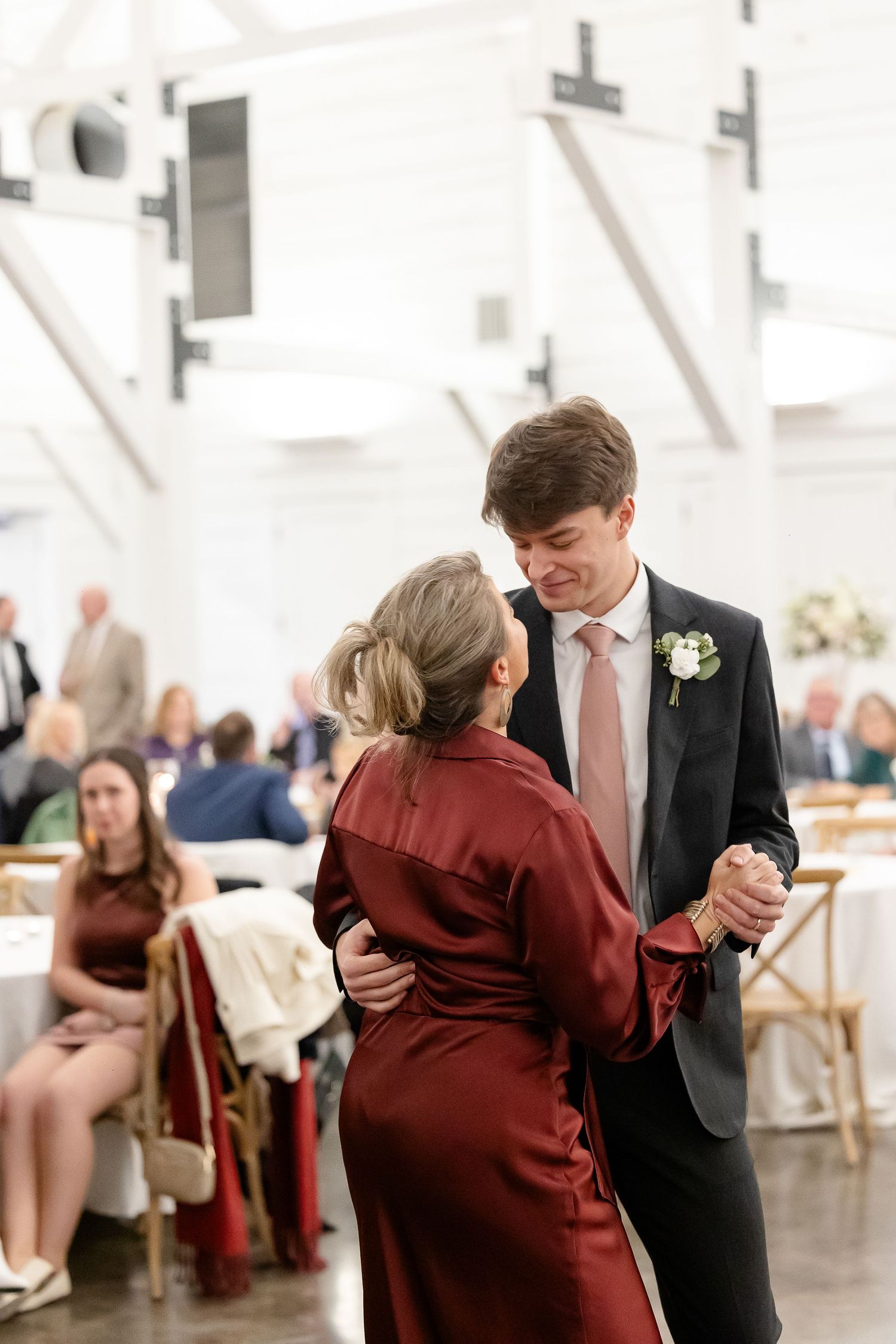 The mother-of-the-groom dances with her son while he smiles sweetly at her. Image by Emily Joy, wedding photographer in Memphis.