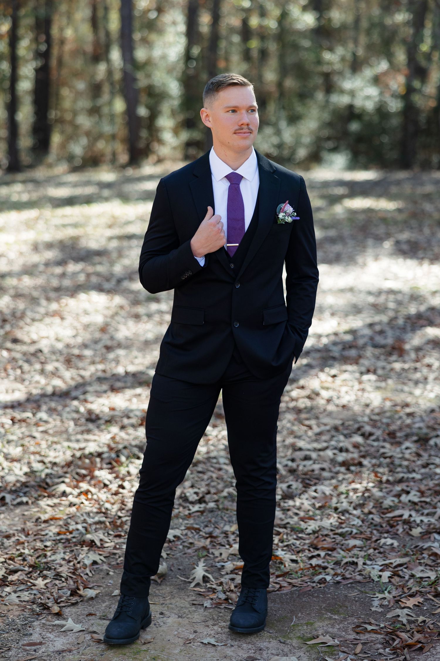 A portrait of a classy groom holding his lapel.