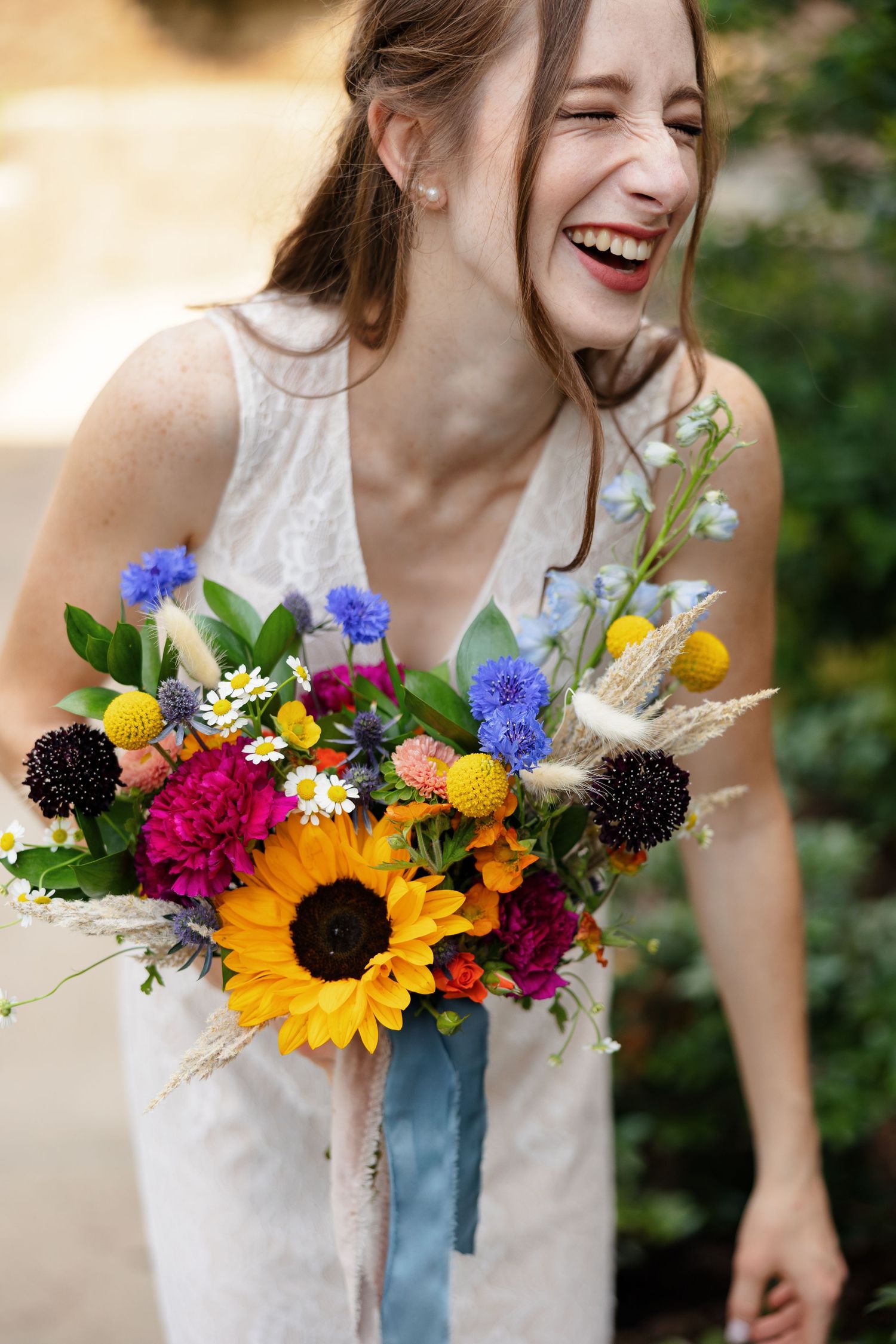 Bride laughing and holding a beautiful bouquet for a portrait by Memphis wedding photographer Emily Joy Photography