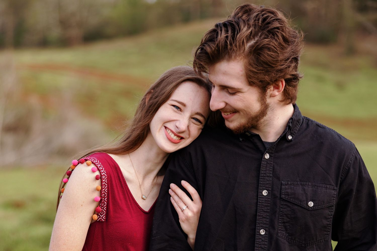 Young lady happy while her fiancé smiles down at her,  by Memphis wedding photographer Emily Joy Photography