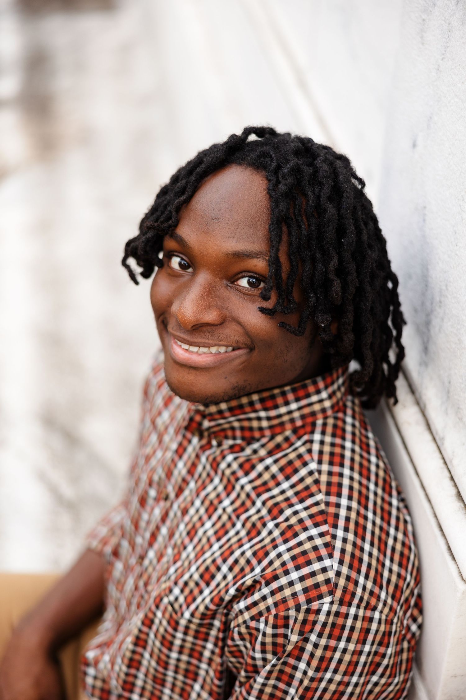 A senior boy smiling for a portrait in front of the Brooks Museum in Memphis, TN.