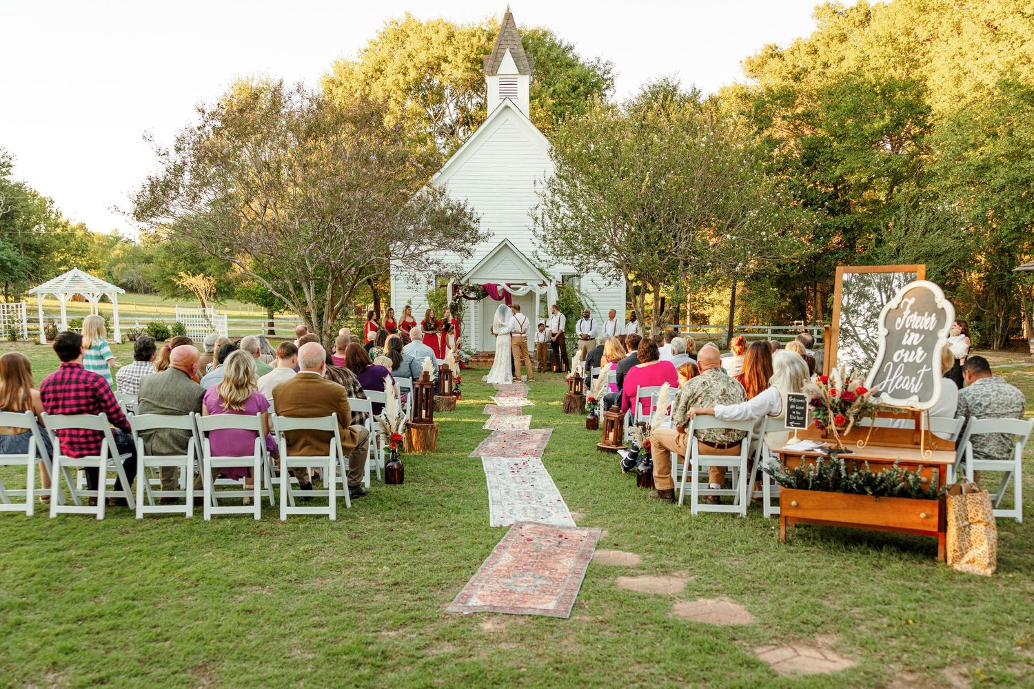 An outdoor ceremony in front of an 1800s white chapel photographed by Emily Joy Photography, now a wedding photographer in Memphis, TN.