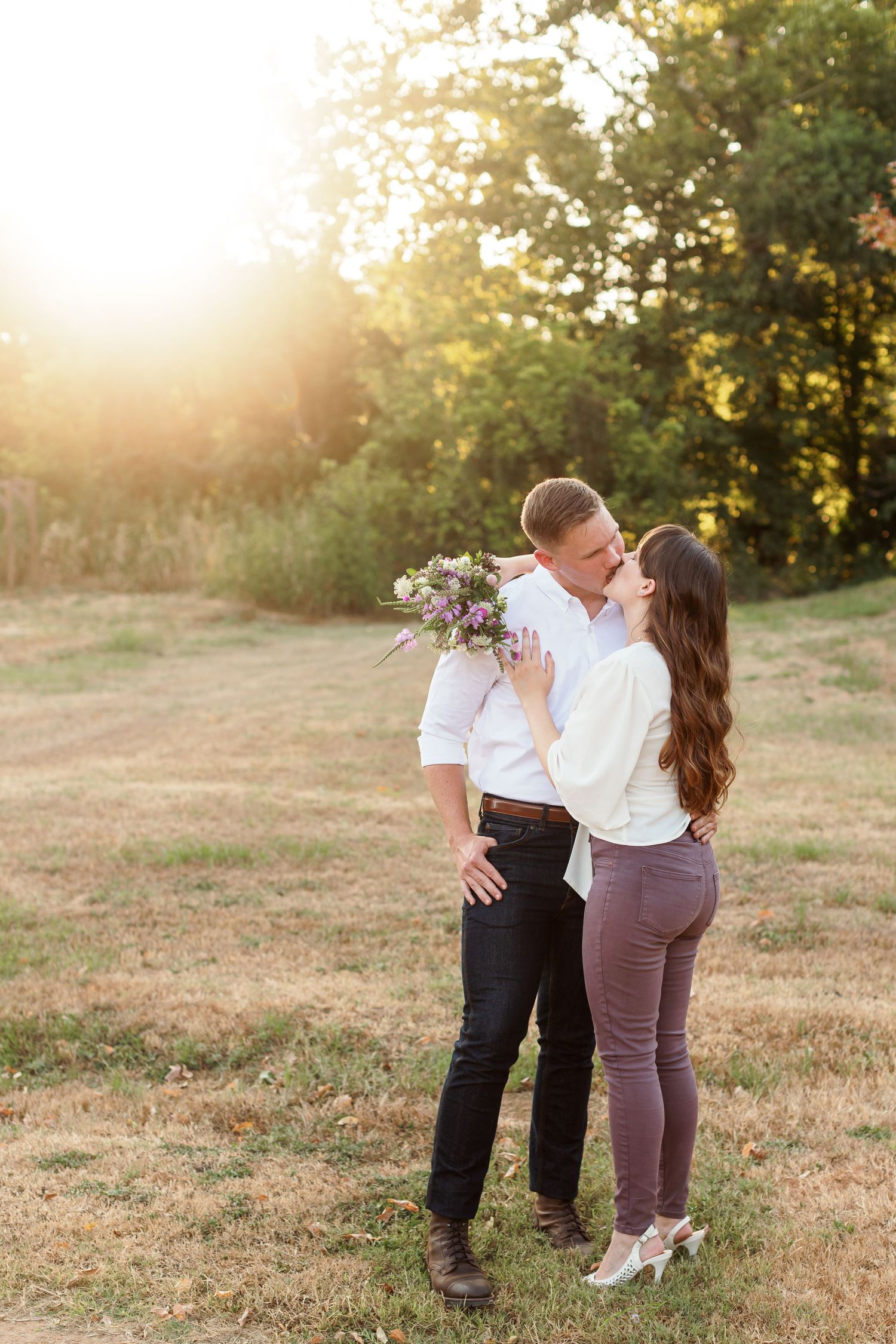 Engaged couple kisses at sunset for a portrait by Emily Joy Photography, now a wedding photographer in Memphis, TN.