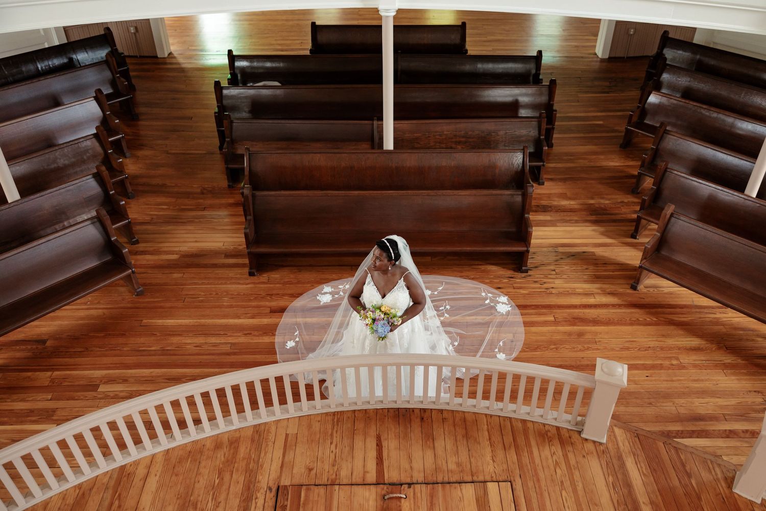 Bride with cathedral length veil, poses in a victorian era chapel for a portrait by Memphis Wedding Photographer Emily Joy Photography