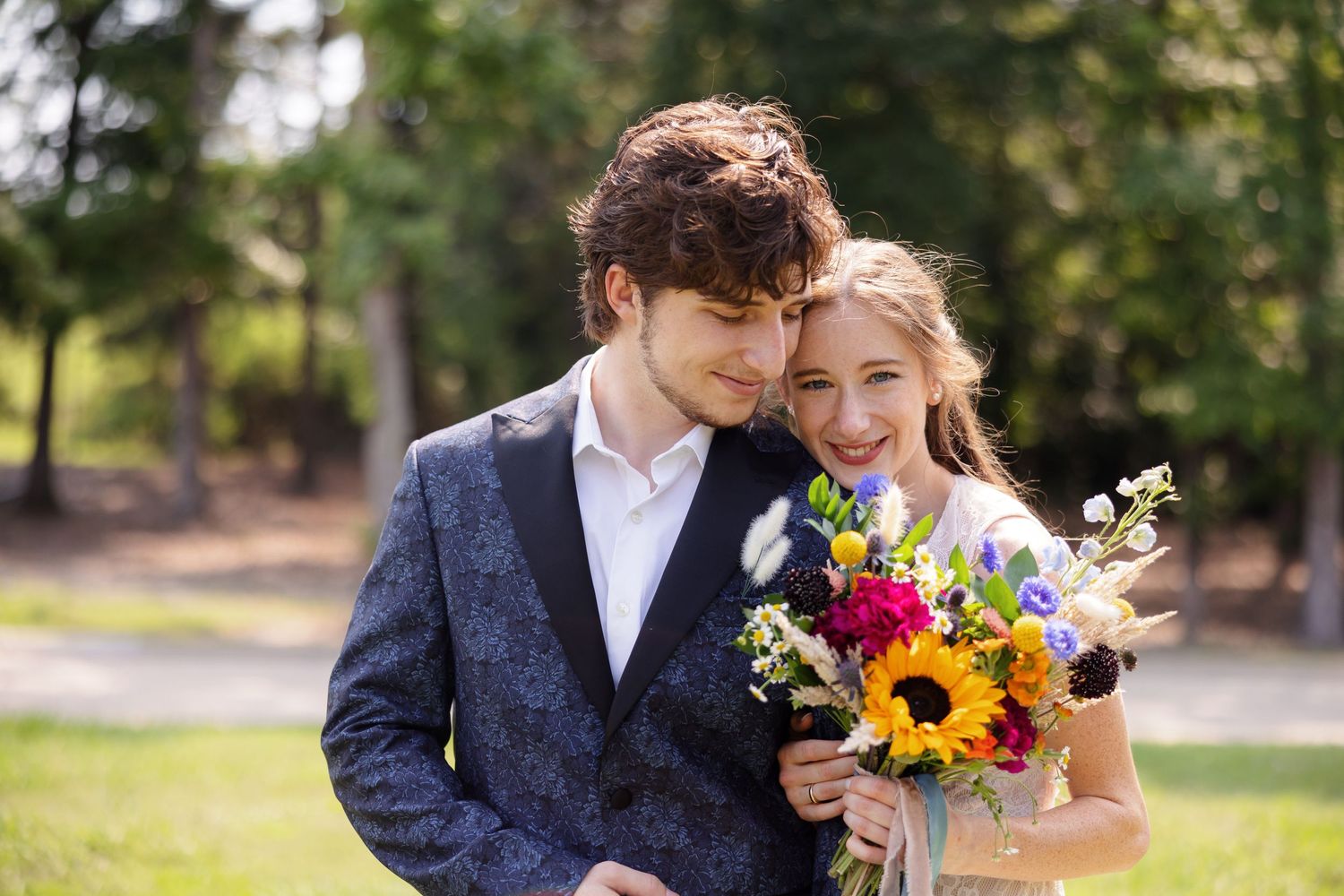 Groom smiles down at Bride who is holding bouquet  for a portrait by Memphis wedding photographer Emily Joy Photography