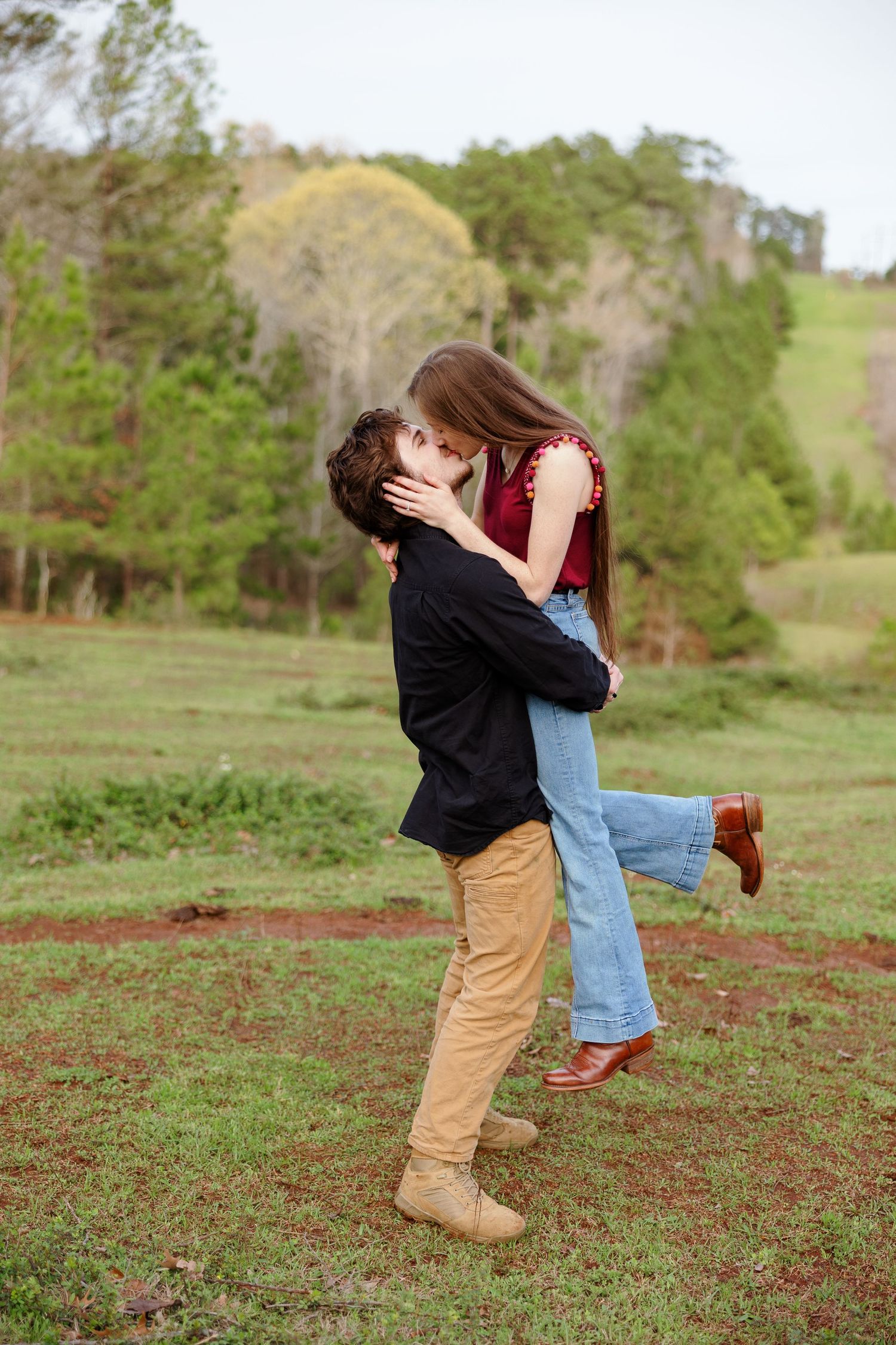 Young couple kisses and her foot pops for a portrait by Memphis wedding photographer Emily Joy Photography