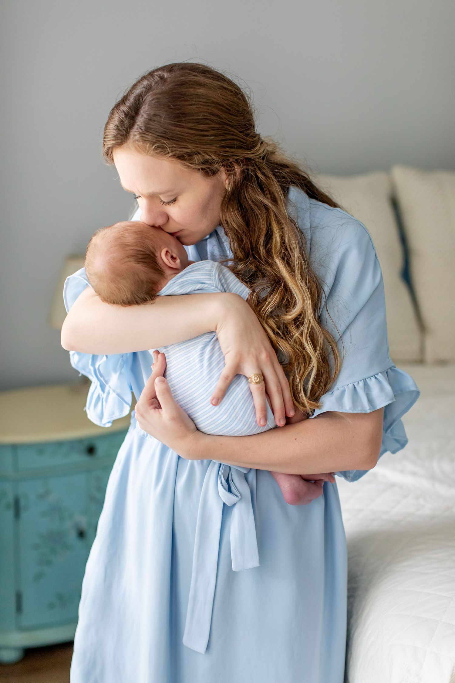A young mother kisses her newborn boy for a portrait by Emily Joy Photography, now a wedding photographer in Memphis, TN.