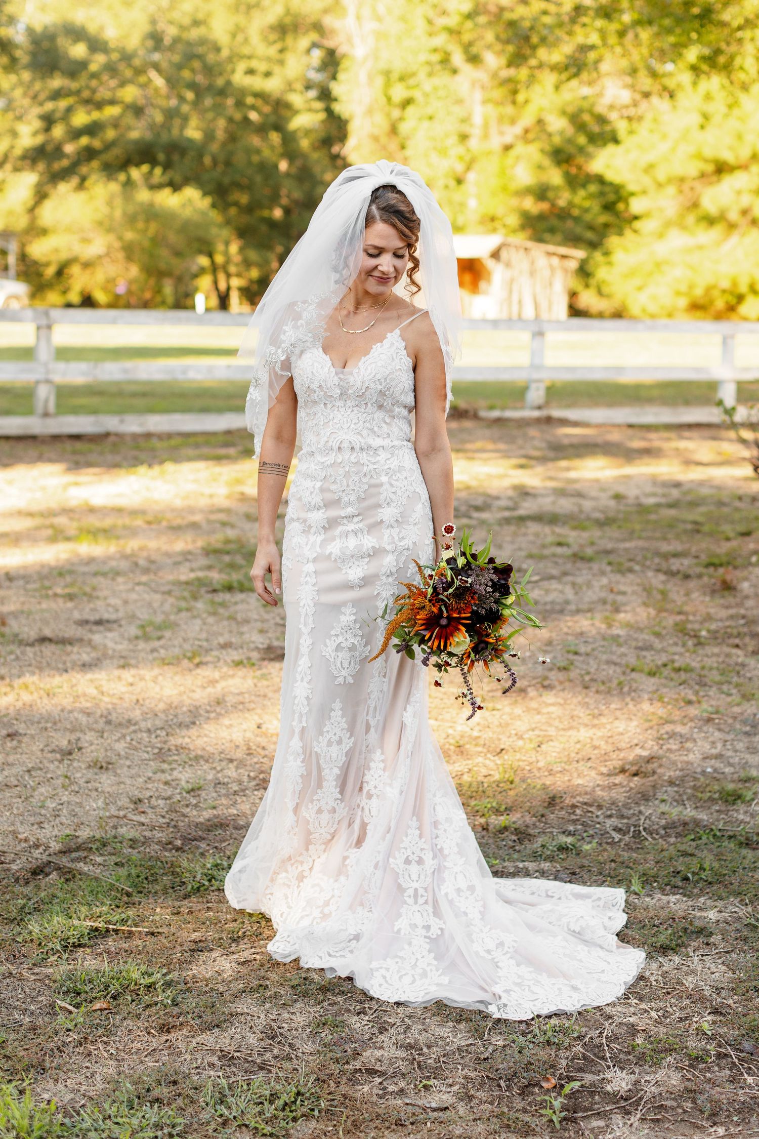 Bride smiles gently down at her bouquet for a portrait photographed by Emily Joy Photography, now a wedding photographer in Memphis, TN.