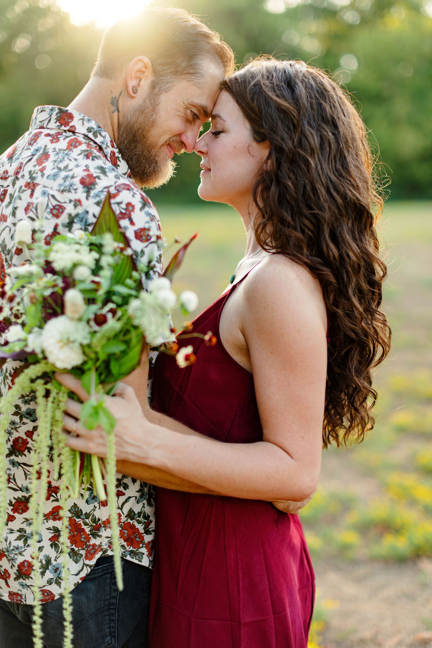 Engaged couple smiles at each other during sunset for a portrait  by Emily Joy Photography, now a wedding photographer in Memphis, TN.