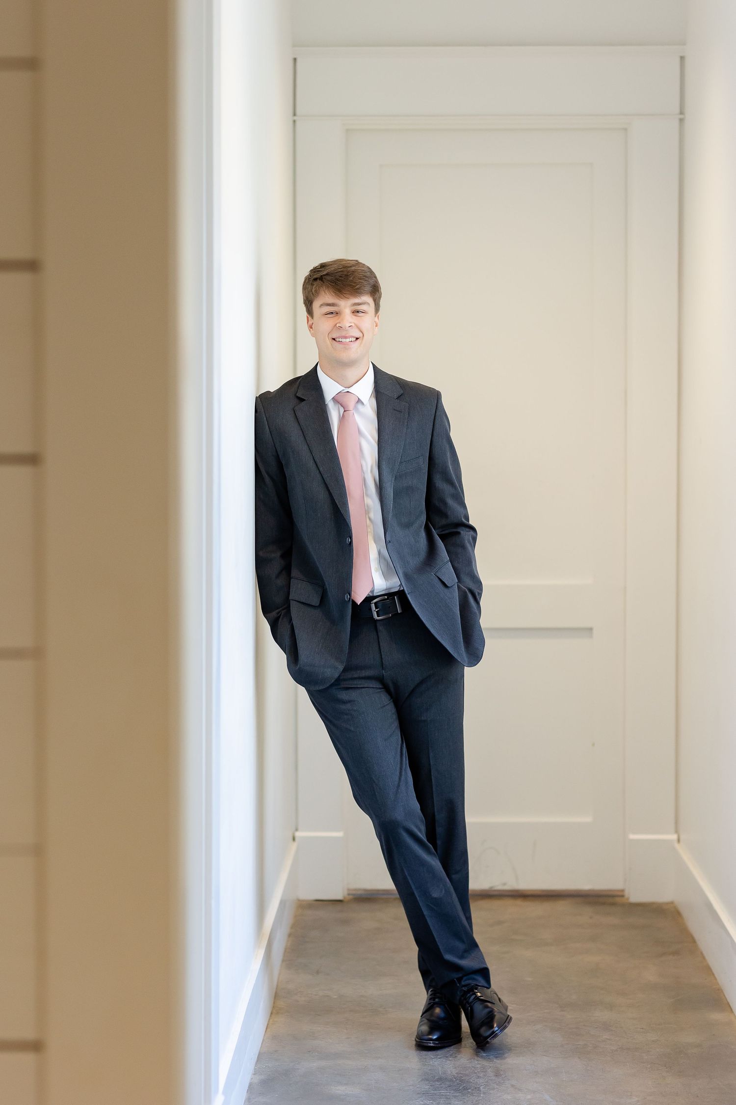 A full length portrait of a groom, casual leaning against a wall. Image by Emily Joy, wedding photographer in Memphis.