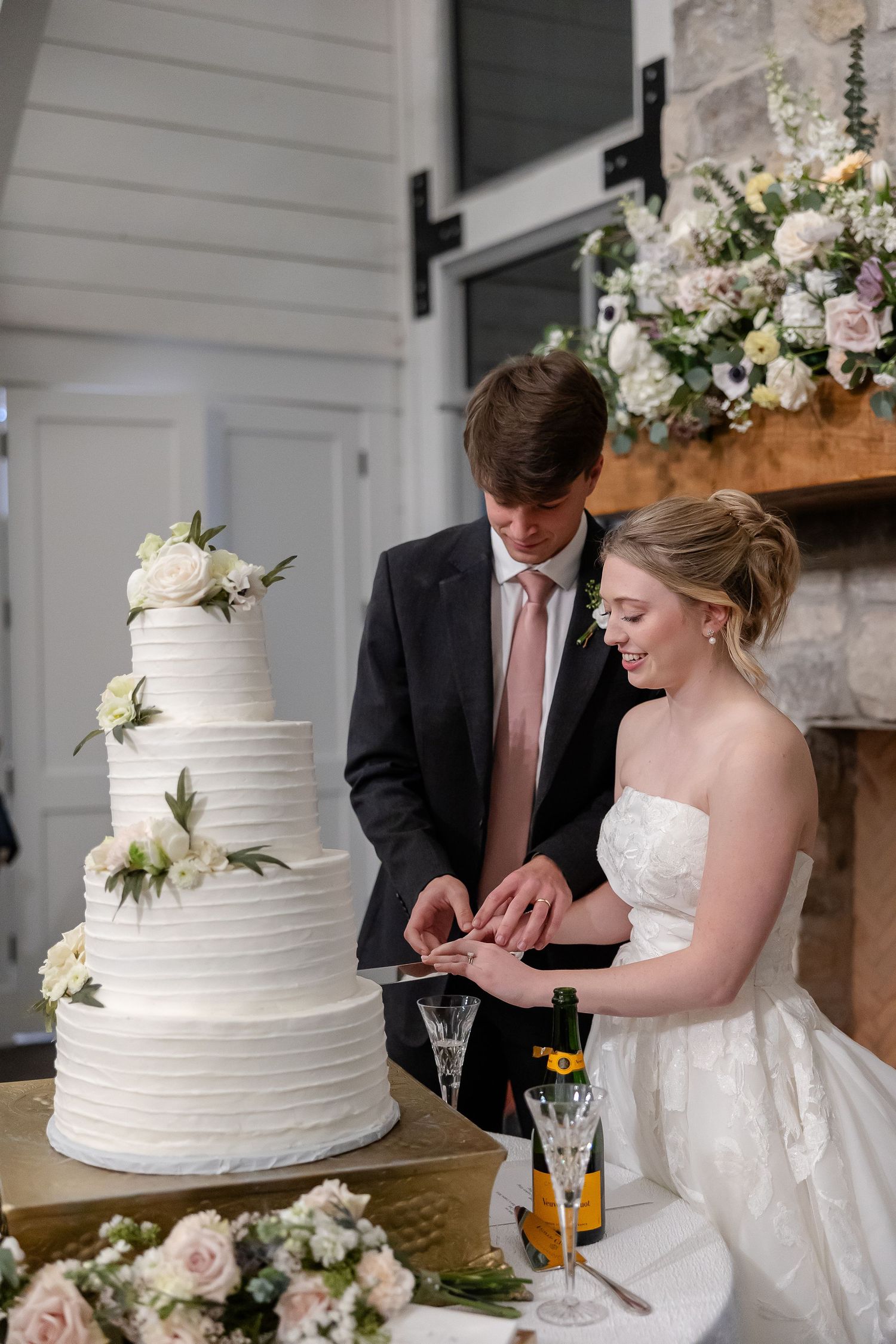 A portrait of a bride and groom cutting their cake by Memphis wedding photographer, Emily Joy Photography.