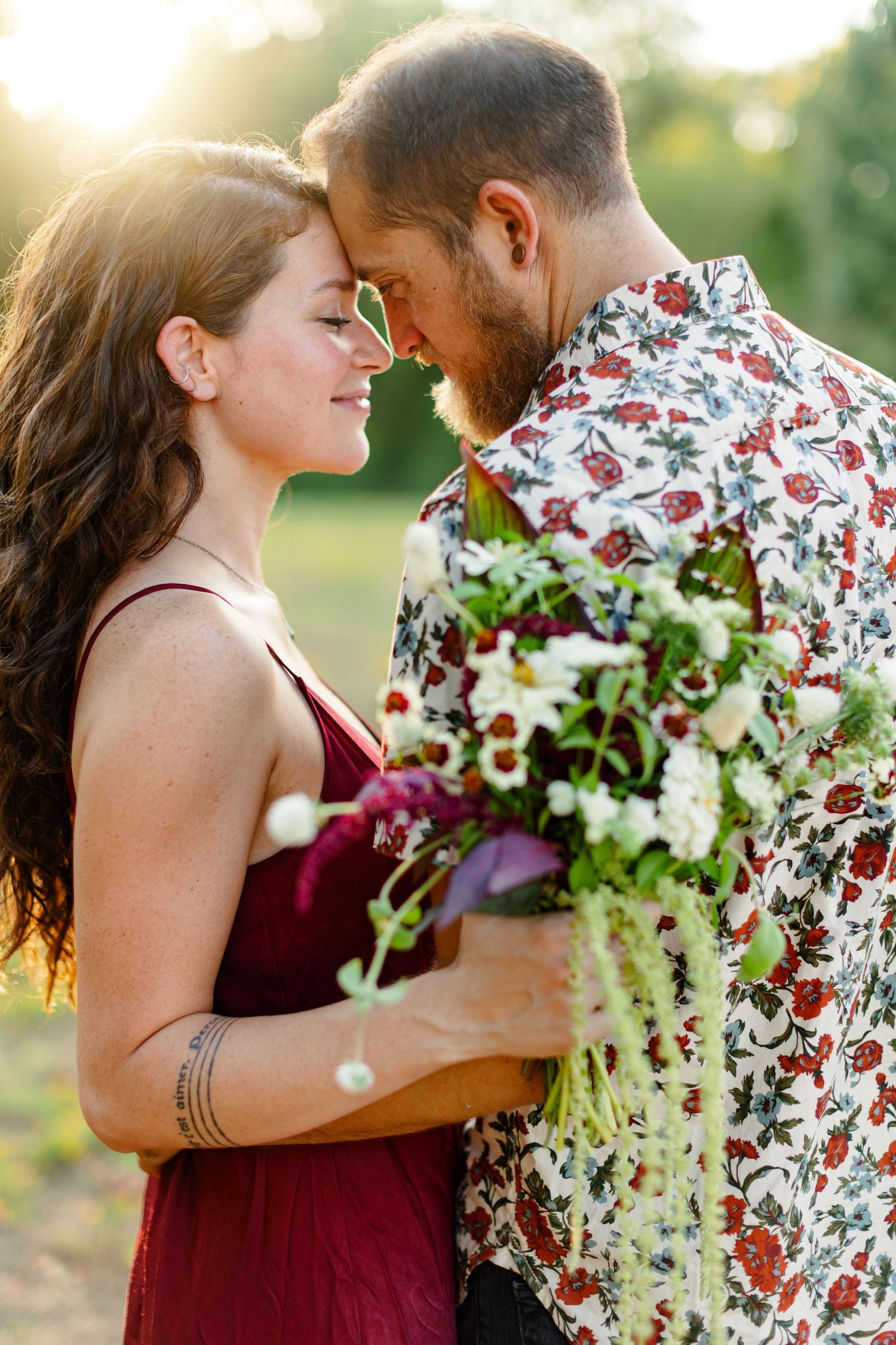 Engaged couple smiles at each other during sunset for a portrait  by Emily Joy Photography, now a wedding photographer in Memphis, TN.