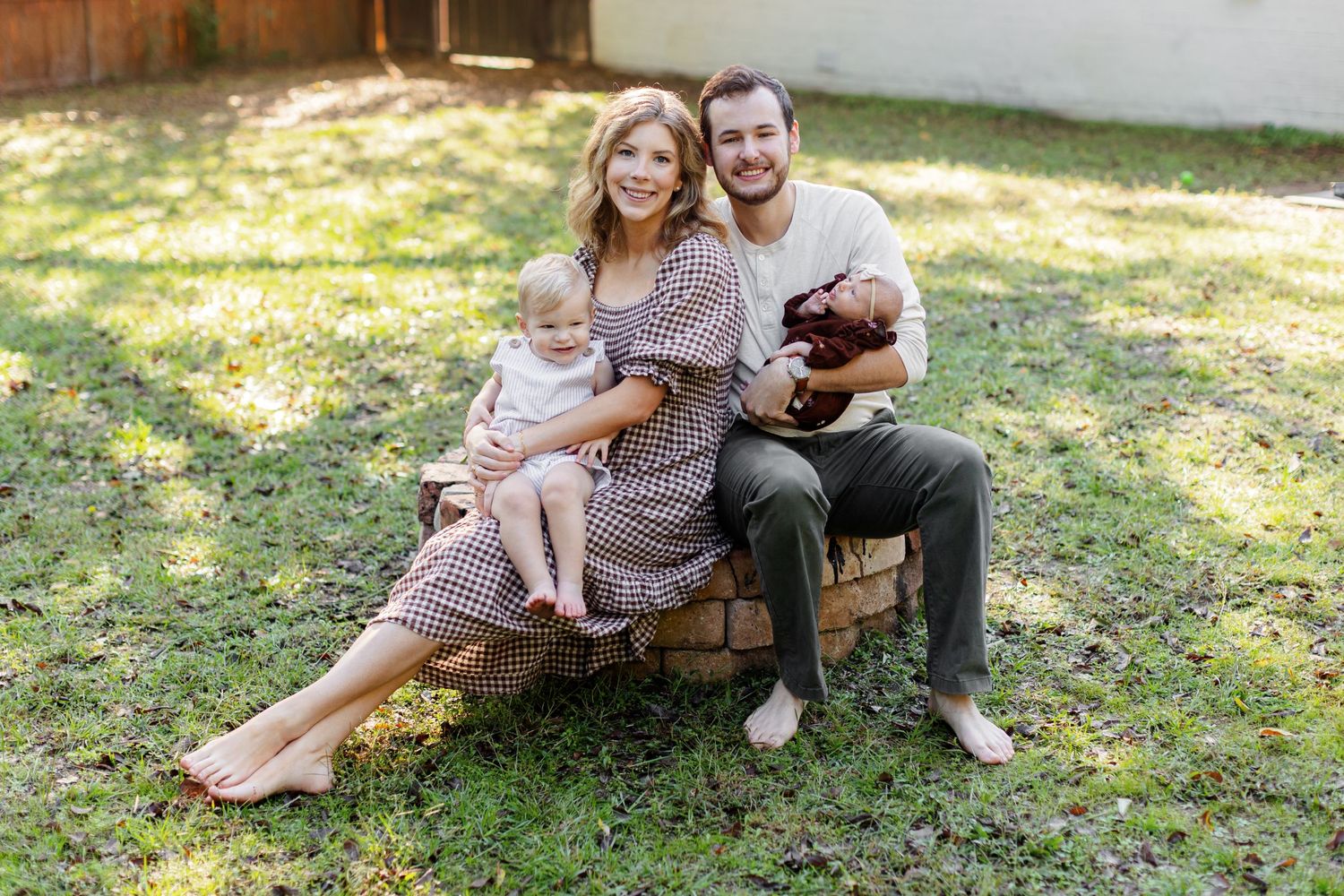 Young family of four smiles at the camera for a portrait  by Memphis wedding photographer Emily Joy Photography