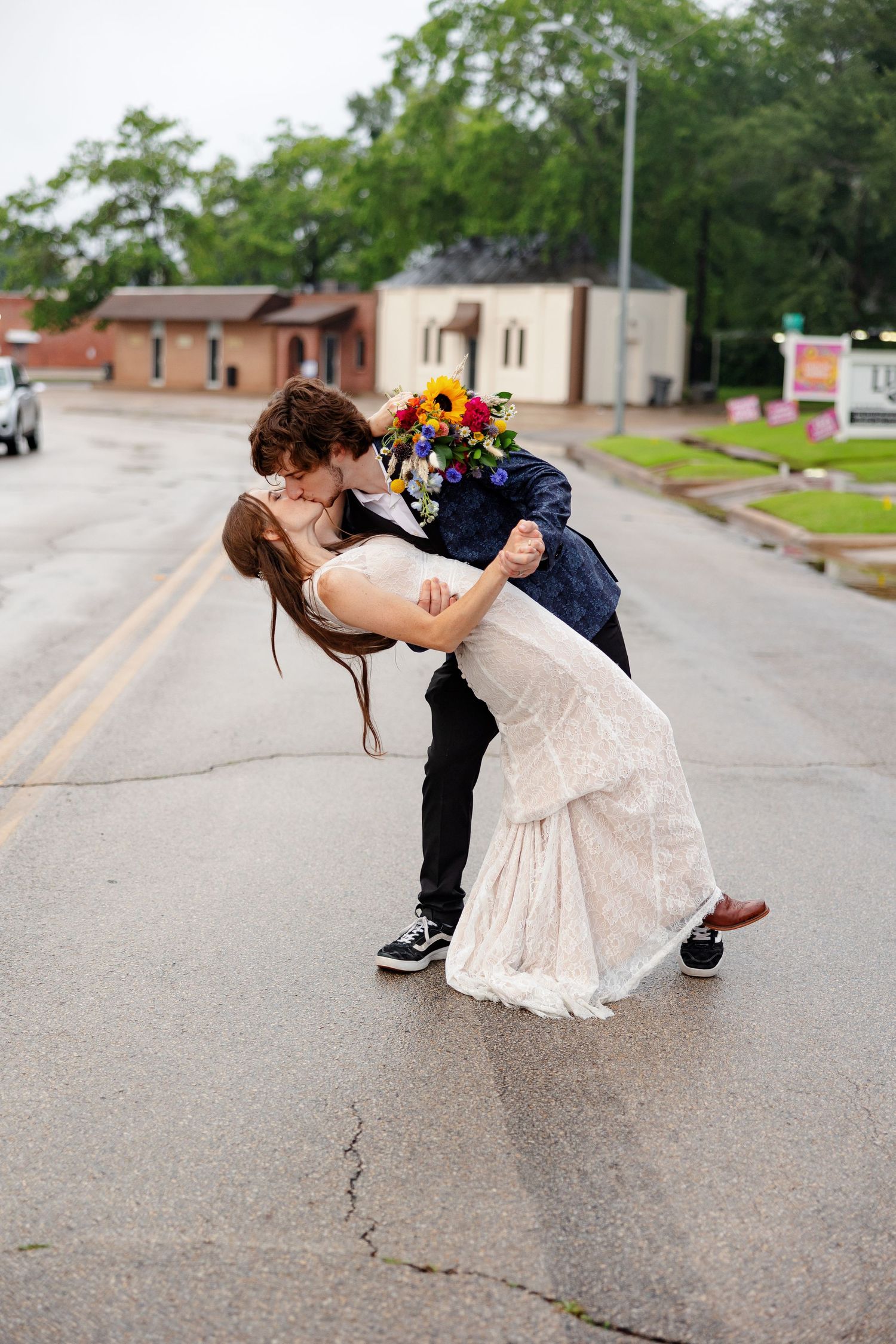 Groom dips the bride for a kiss for a portrait by Memphis wedding photographer Emily Joy Photography