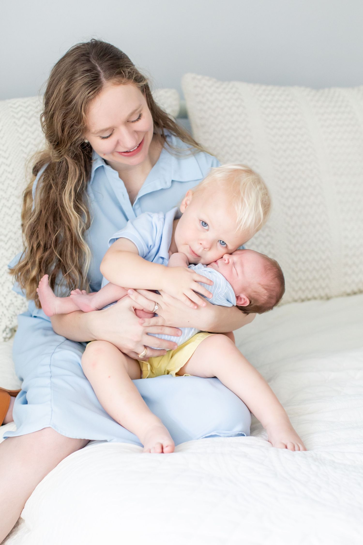 A toddler welcomes his newborn brother for a portrait by Emily Joy Photography, now a wedding photographer in Memphis, TN.