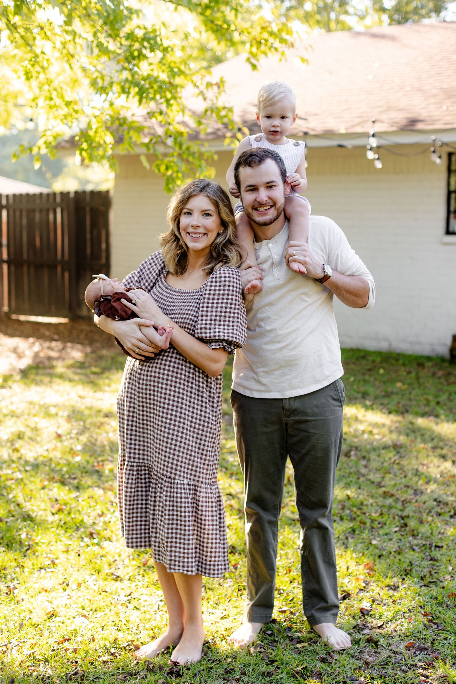 Young family smiling at camera for a portrait by Memphis wedding photographer Emily Joy Photography