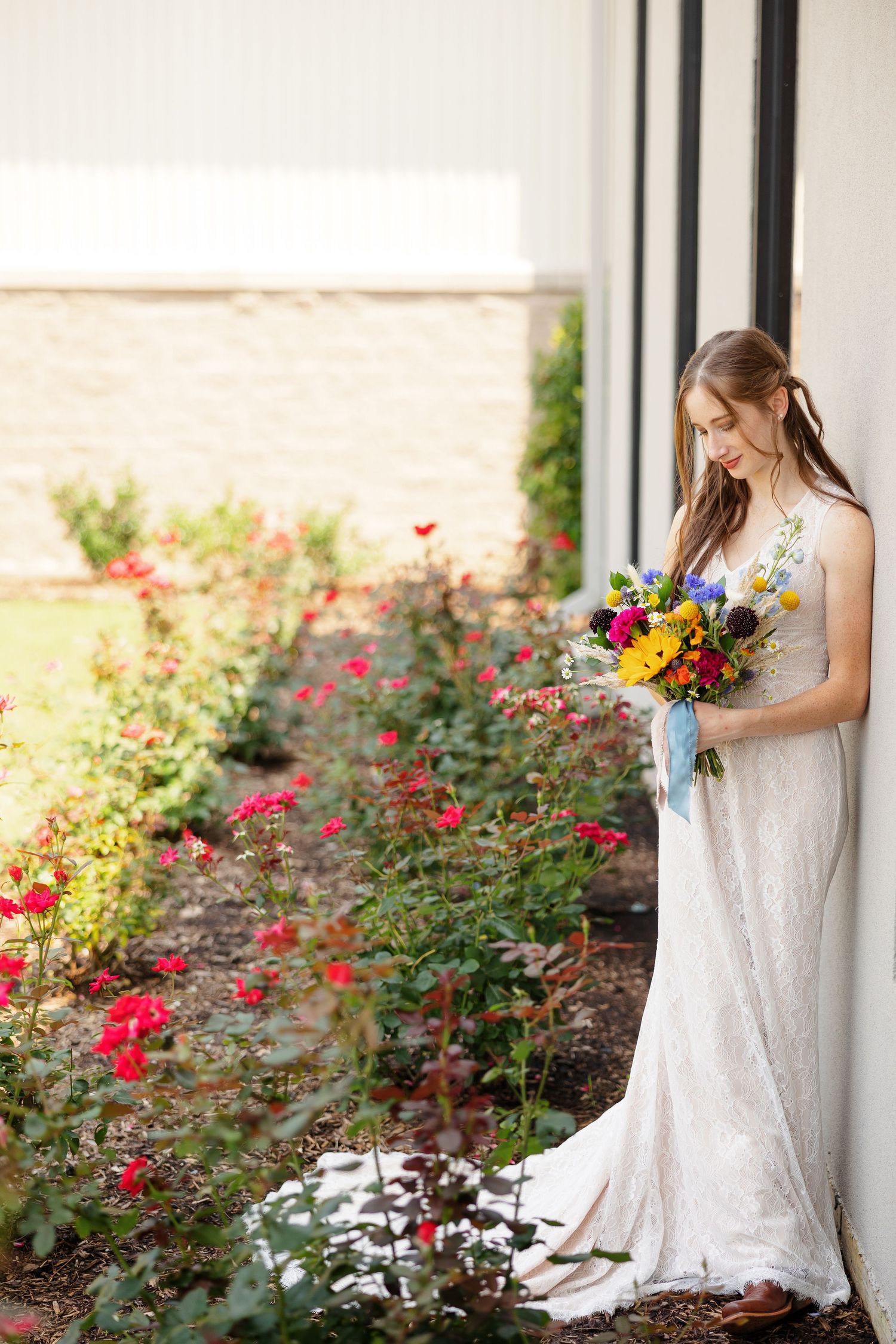 Bride wistfully views her bouquet for a portrait by Memphis wedding photographer Emily Joy Photography