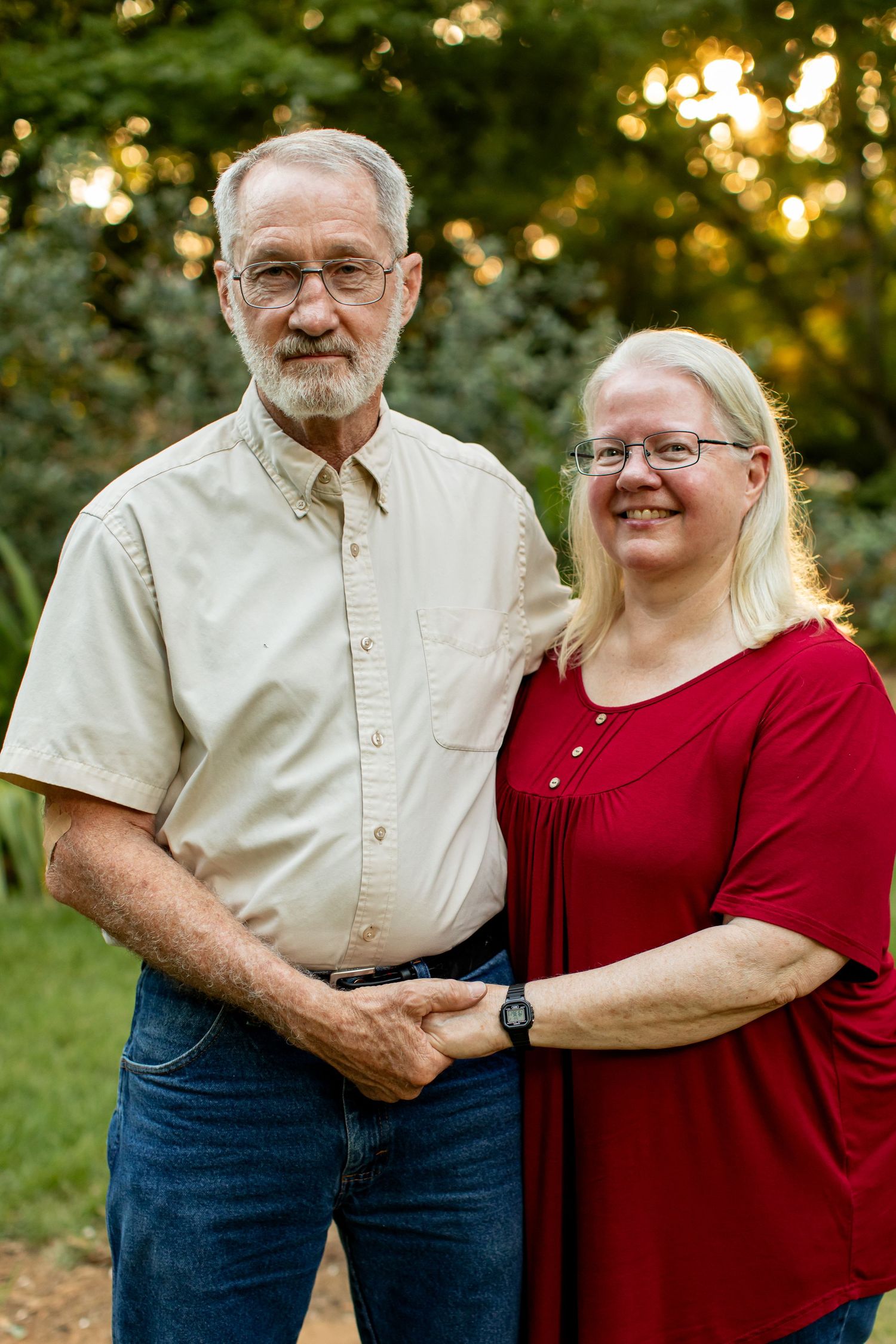 A husband and wife hold hands and smile for a portrait by Emily Joy Photography, now a wedding photographer in Memphis, TN.