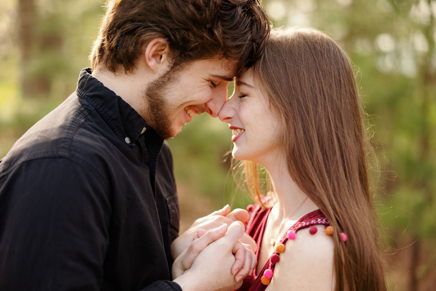 Young couple hold hands, giggle , faces close, for a portrait by Memphis wedding photographer Emily Joy Photography