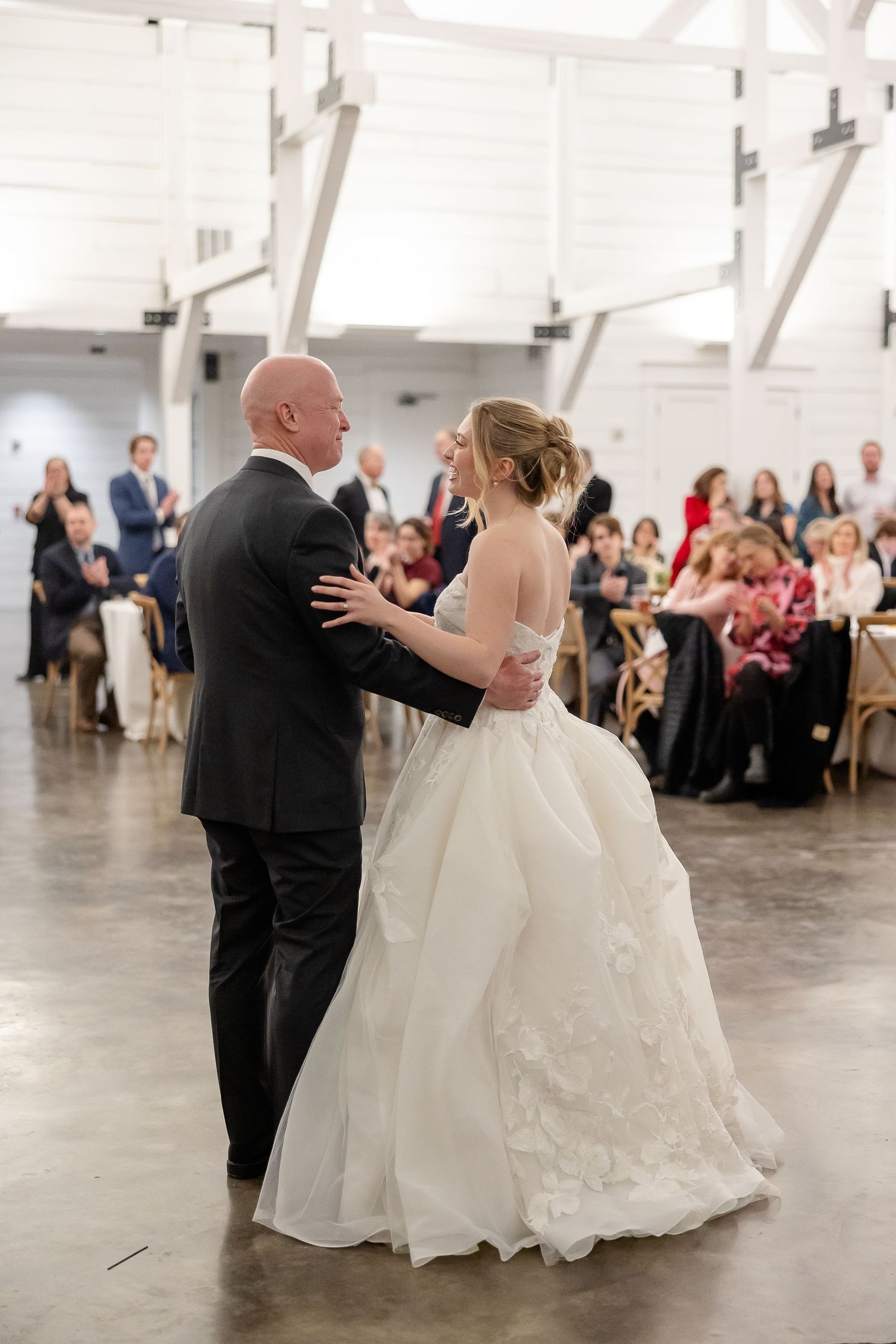 The father-of-the-bride dances with the bride as they smile lovingly at each other. Image by Emily Joy, wedding photographer in Memphis.