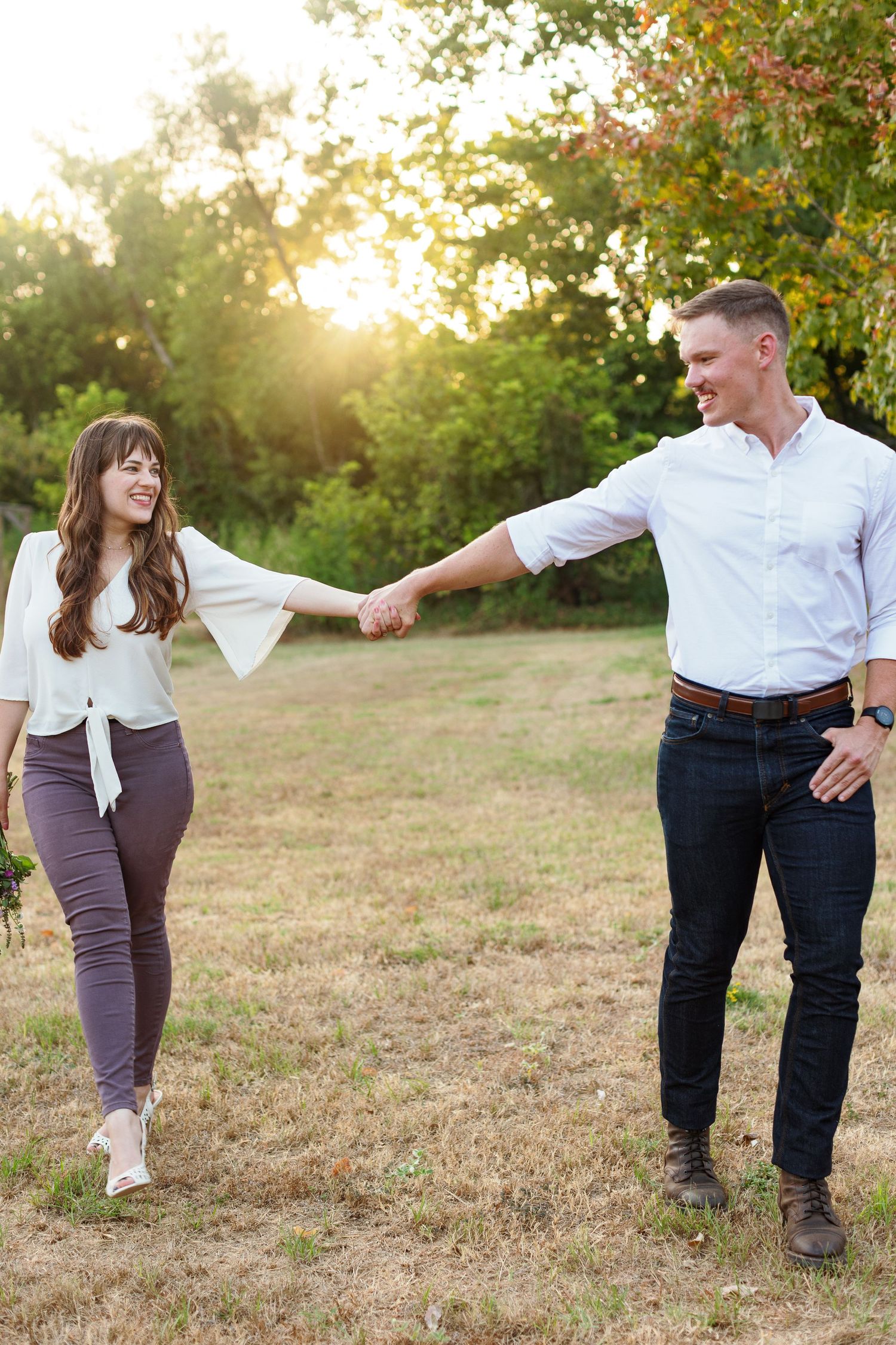 An engaged couple walking and holding hands for a portrait by Emily Joy Photography, now a wedding photographer in Memphis, TN.