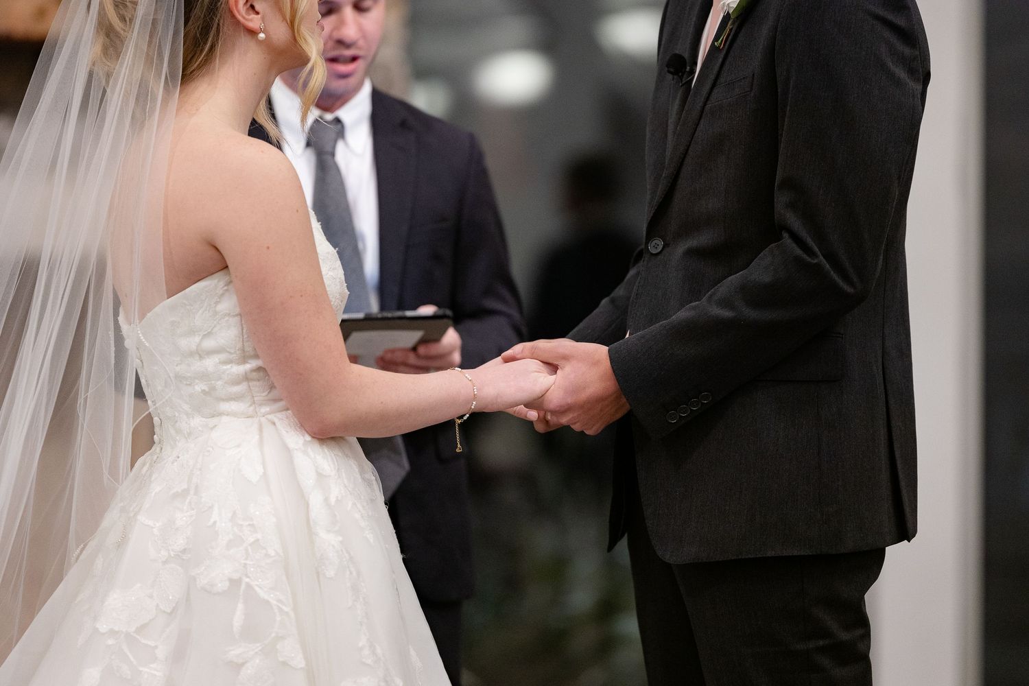 A bride and groom gently face each other and hold hands during their wedding ceremony. Image by Emily Joy, wedding photographer in Memphis.