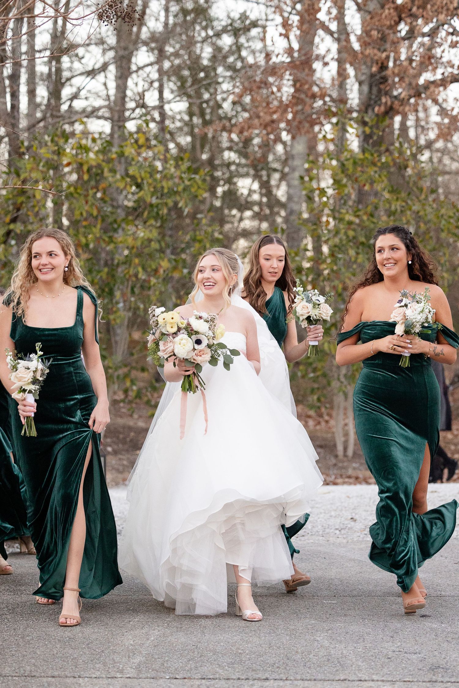 Bride and bridesmaids walk around the Robinshaw wedding venue to line up for processional as ceremony begins.