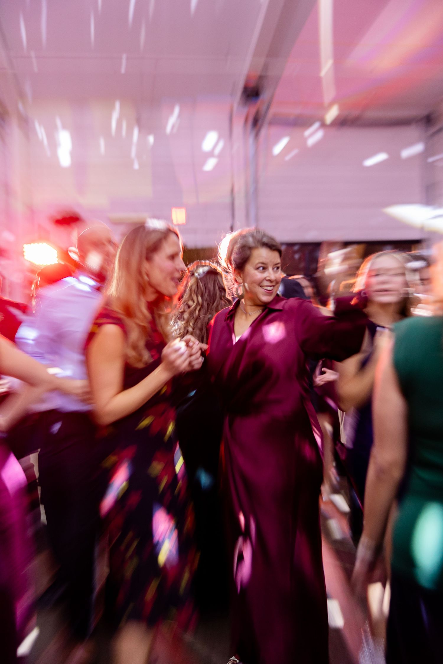 The mother of the groom enjoys the reception festivities while talking to her friend. Image by Emily Joy, wedding photographer in Memphis.