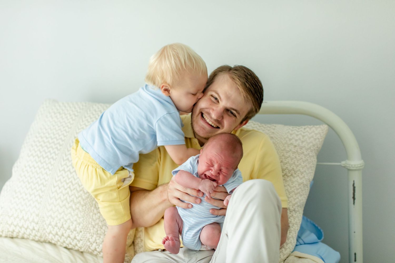 A young father playfully interacts with his two sons for a portrait by Emily Joy Photography, now a wedding photographer in Memphis, TN.