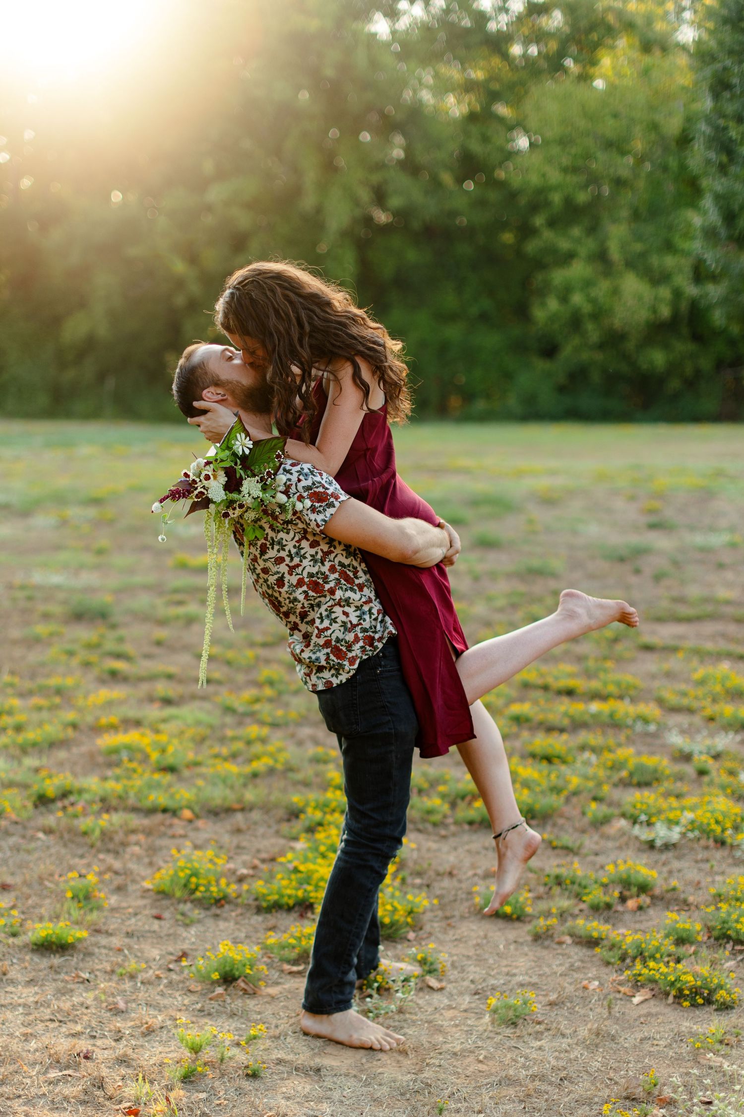 Engaged couple kisses, backlit by sunset for a portrait  by Emily Joy Photography, now a wedding photographer in Memphis, TN.