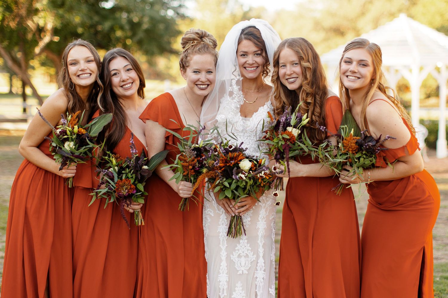 Bride with Bridesmaids joyfully huddled around herphotographed by Emily Joy Photography, now a wedding photographer in Memphis, TN.