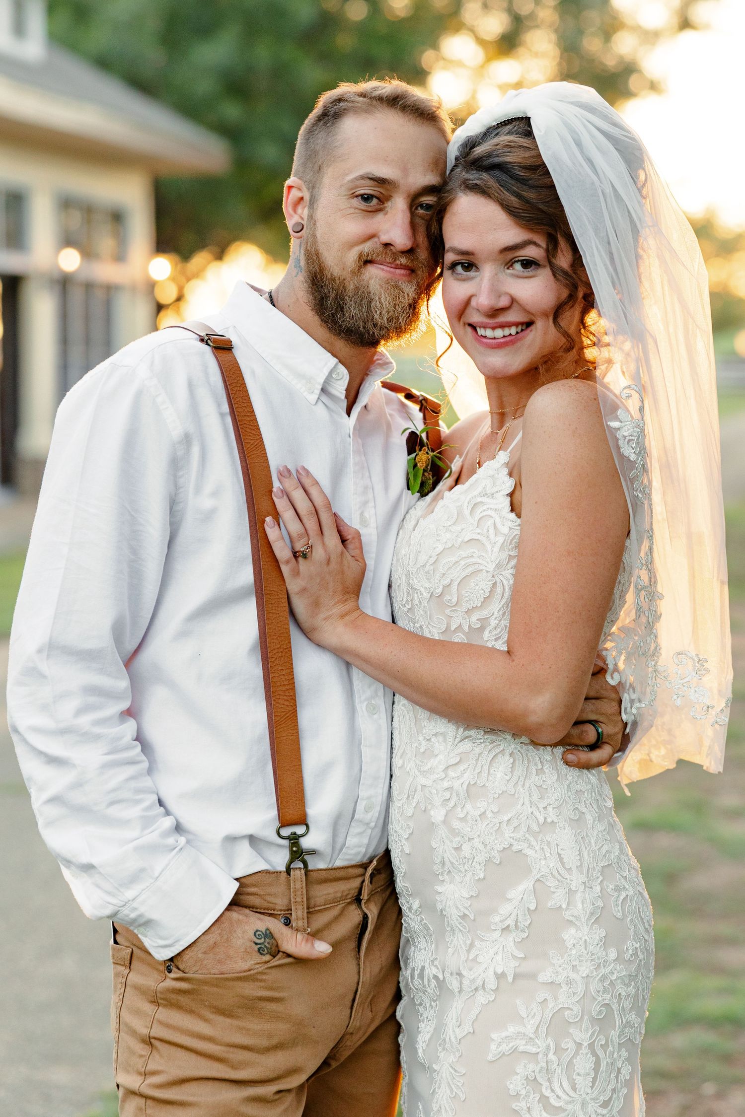 A bearded groom and a veiled bride hug and smile for a portrait by Emily Joy Photography, now a wedding photographer in Memphis, TN.