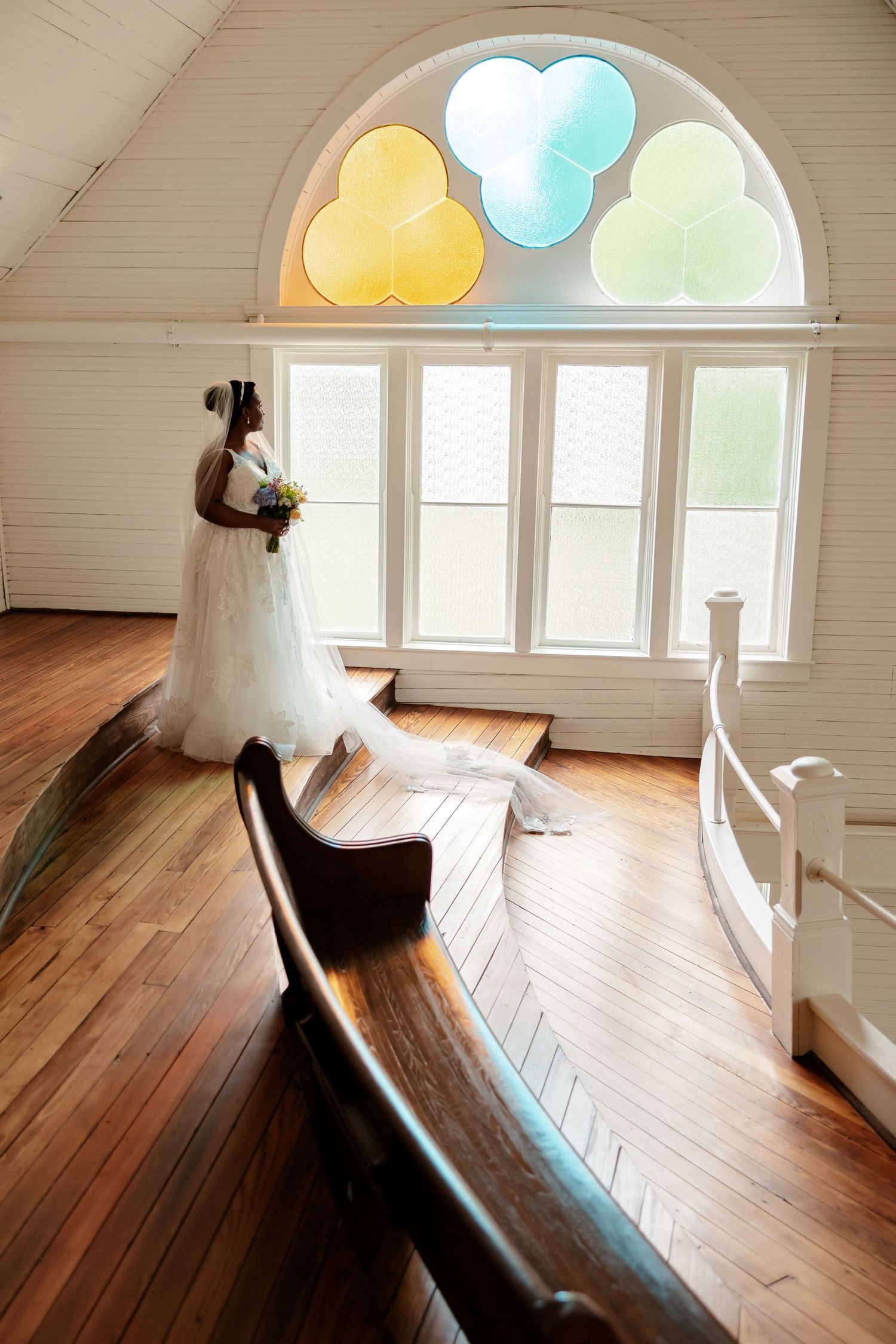A bride in an elegant gown stands in a Victorian chapel for portrait by Memphis Wedding Photographer Emily Joy Photography