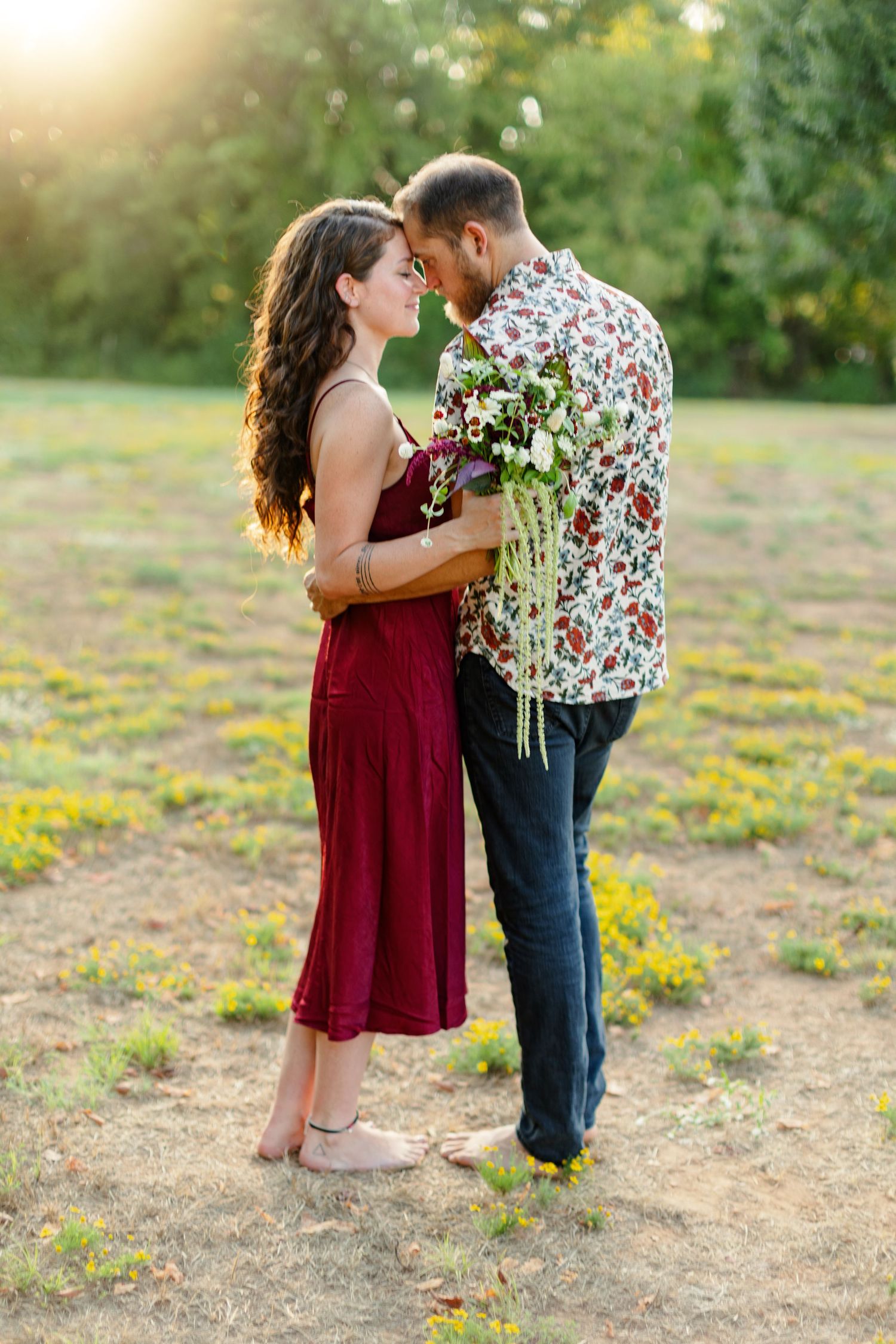 Engaged couple embraces during sunset for a portrait  by Emily Joy Photography, now a wedding photographer in Memphis, TN.