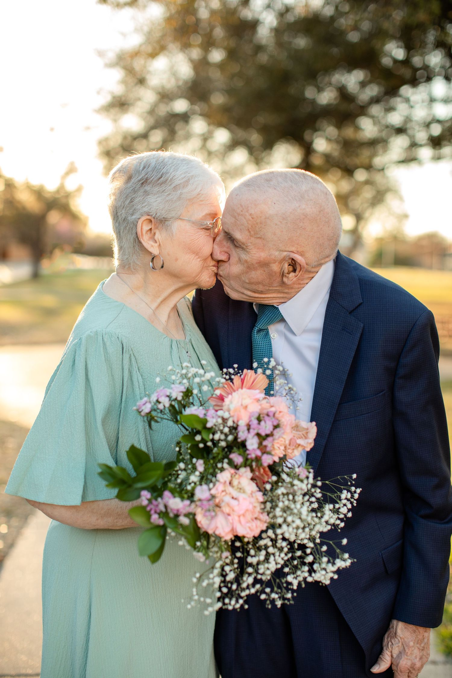 An elderly couple kisses on their anniversary for a portrait by Emily Joy Photography, now a wedding photographer in Memphis, TN.