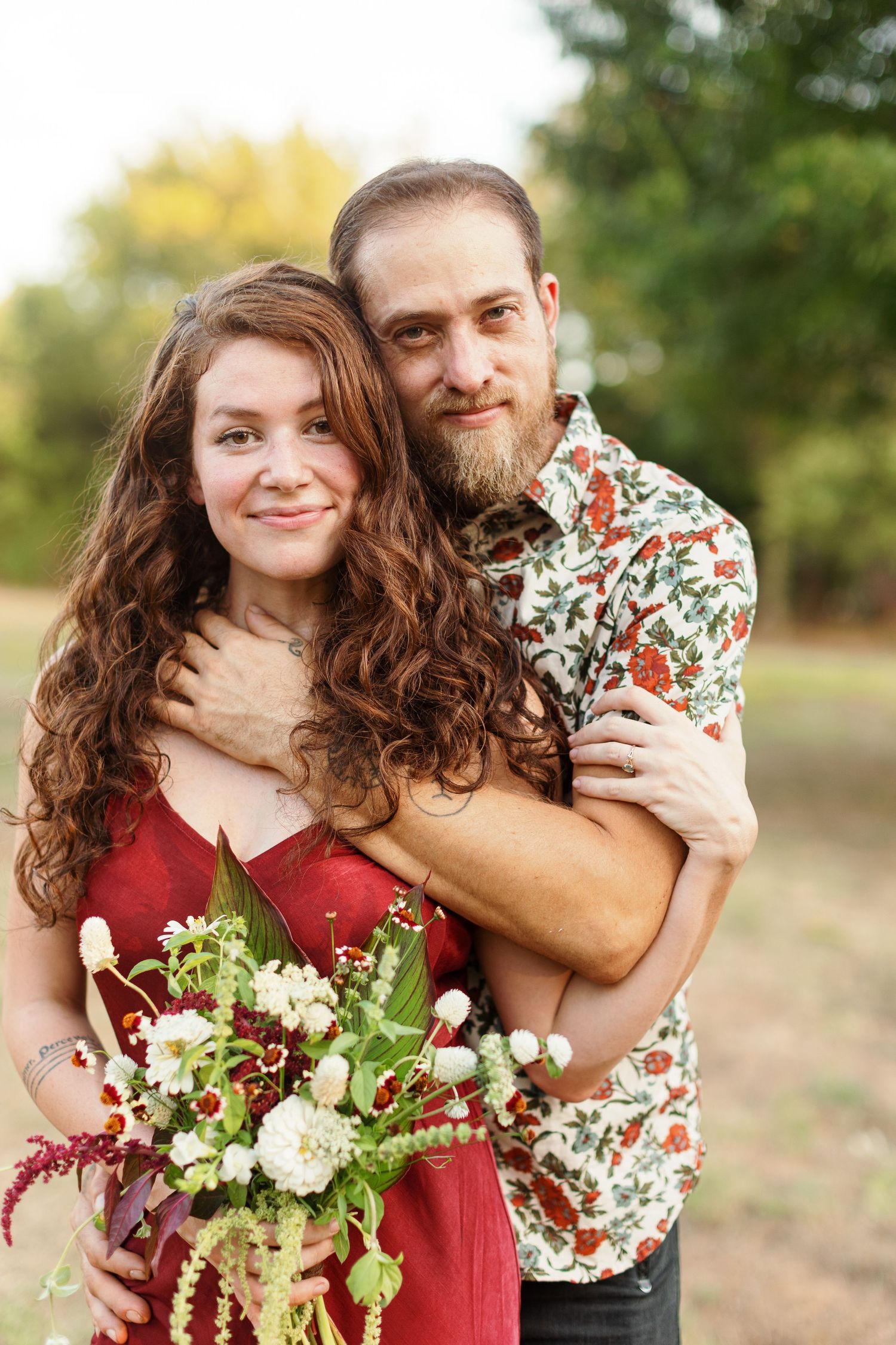 Engaged young couple hugs and smiles for a portrait  by Emily Joy Photography, now a wedding photographer in Memphis, TN.