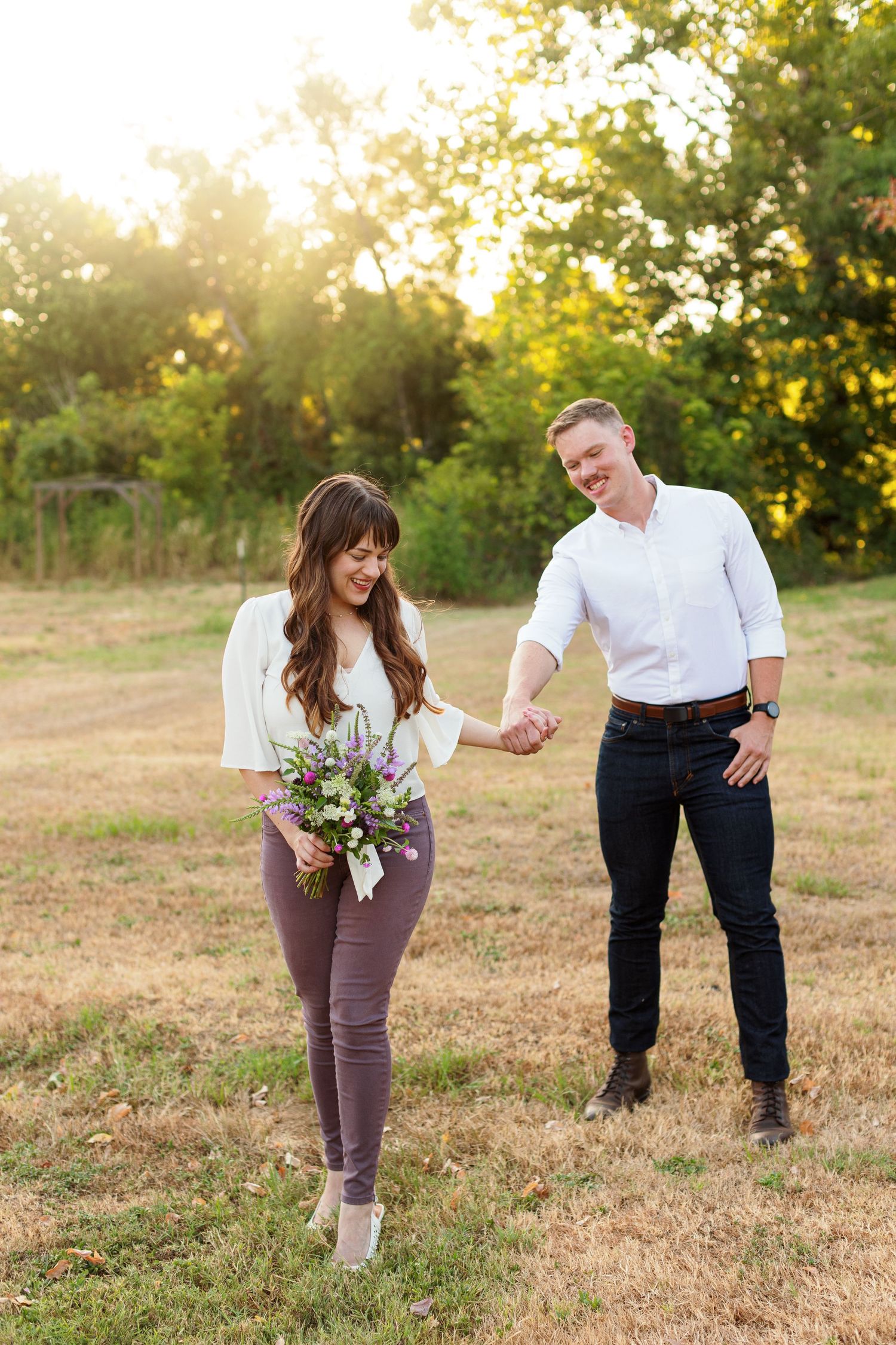 An engaged couple walking and holding hands for a portrait by Emily Joy Photography, now a wedding photographer in Memphis, TN.