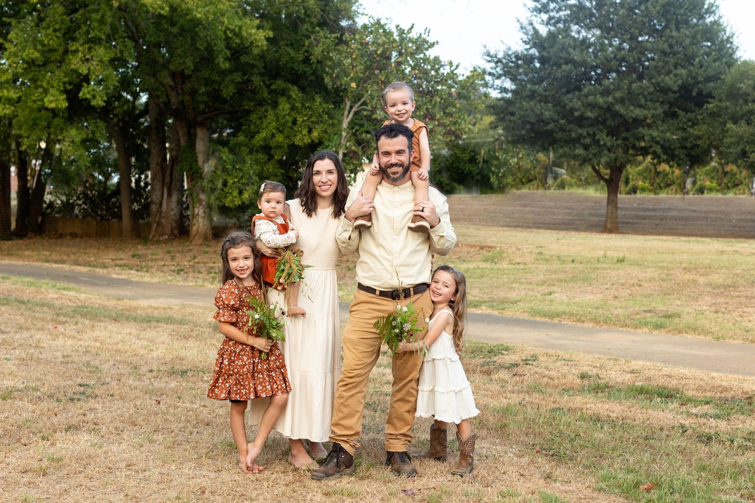 Family of six smiles at the camera for a portrait  by Emily Joy Photography, now a wedding photographer in Memphis, TN.