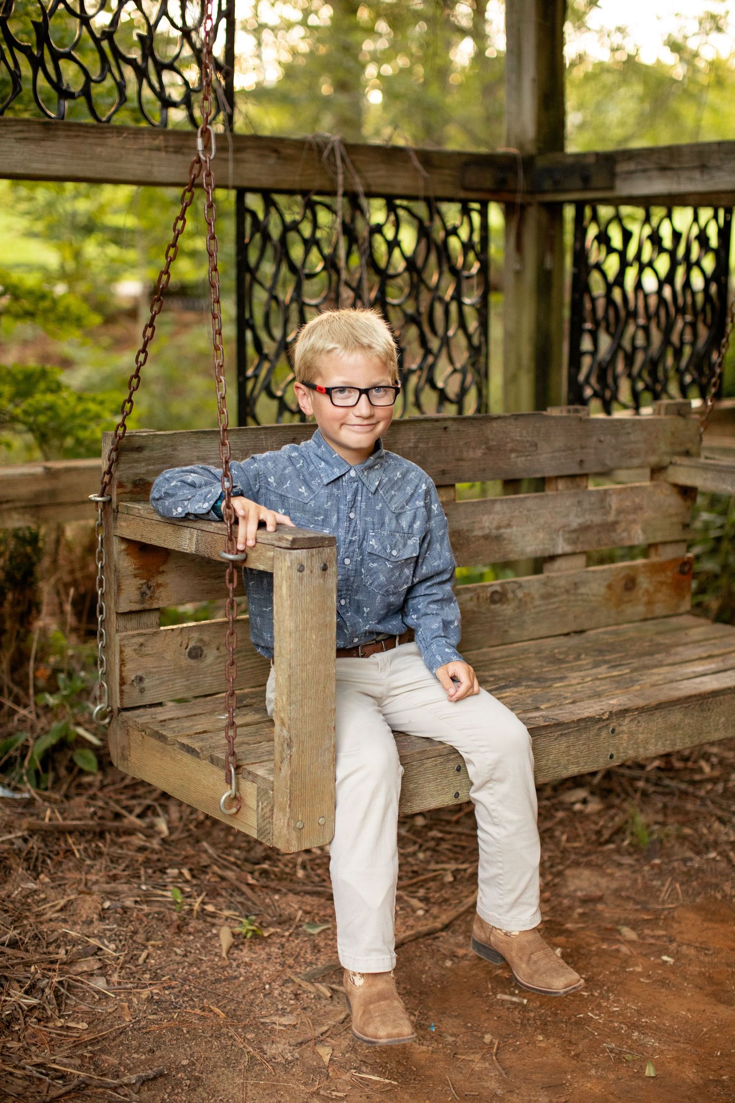 Young boy on a swing smiles for a portrait by Emily Joy Photography, now a wedding photographer in Memphis, TN.